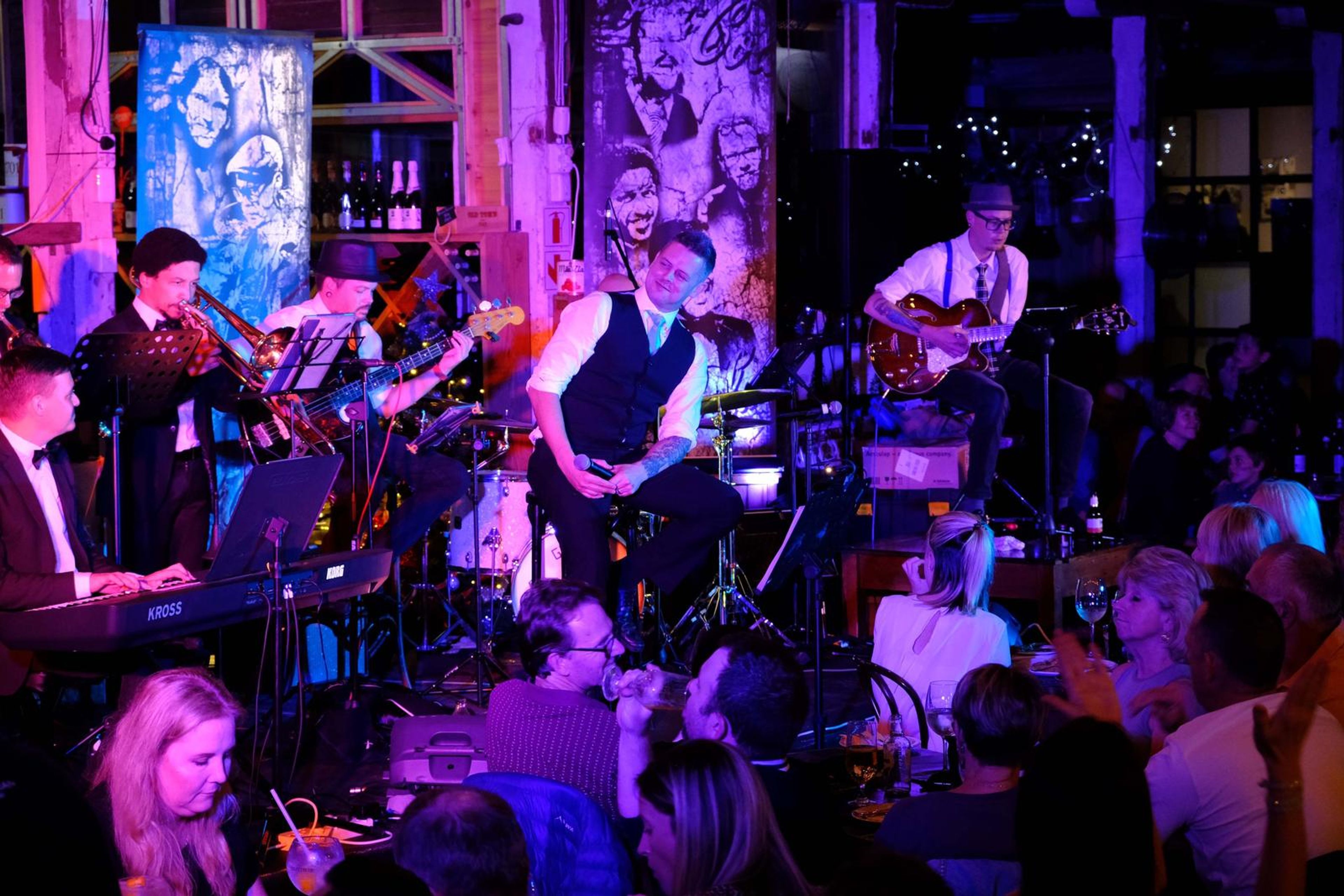 Band playing in front of a large mural wall