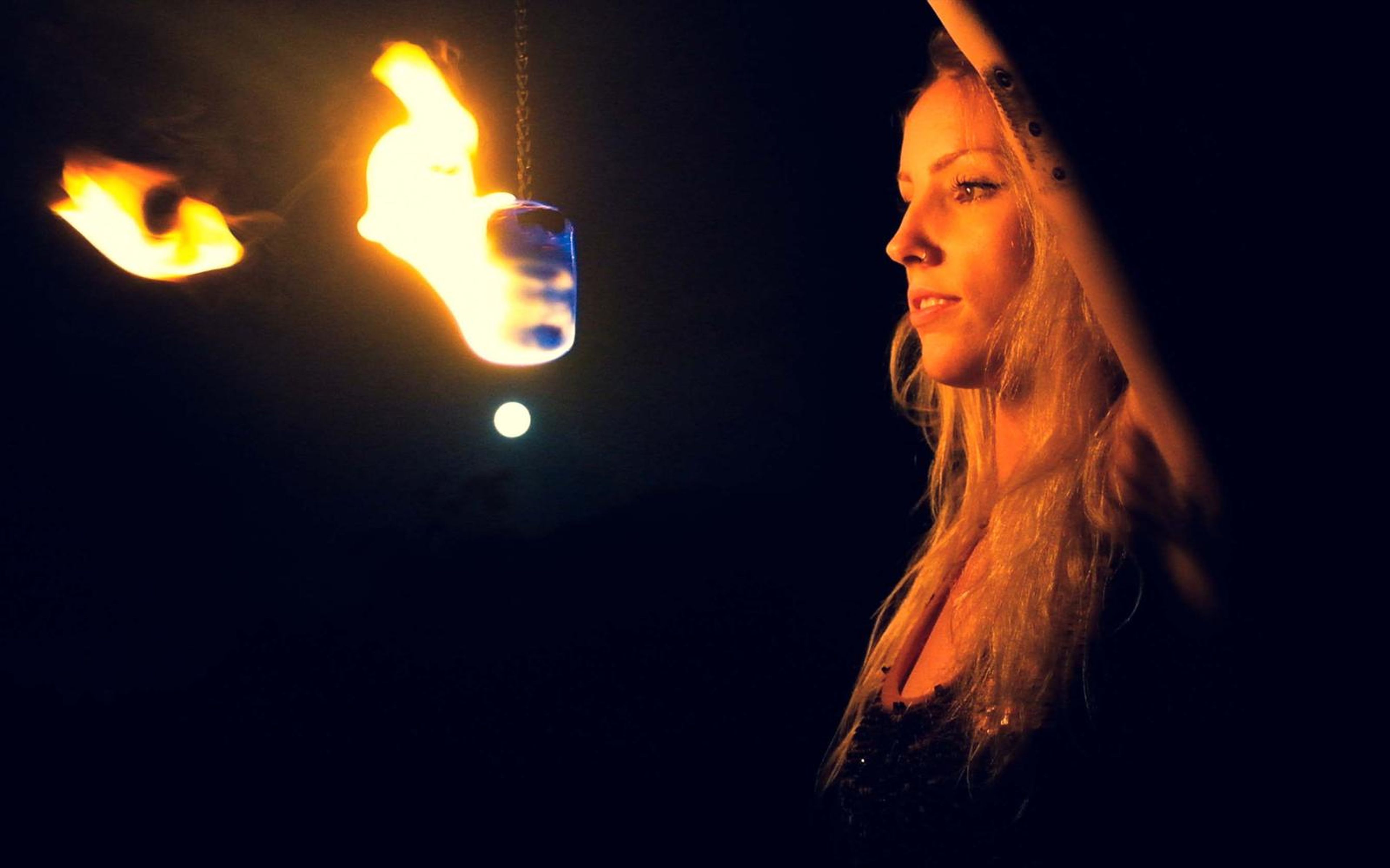 Cooler blue-toned version of the night scene with a woman in profile beside a burning fire poi