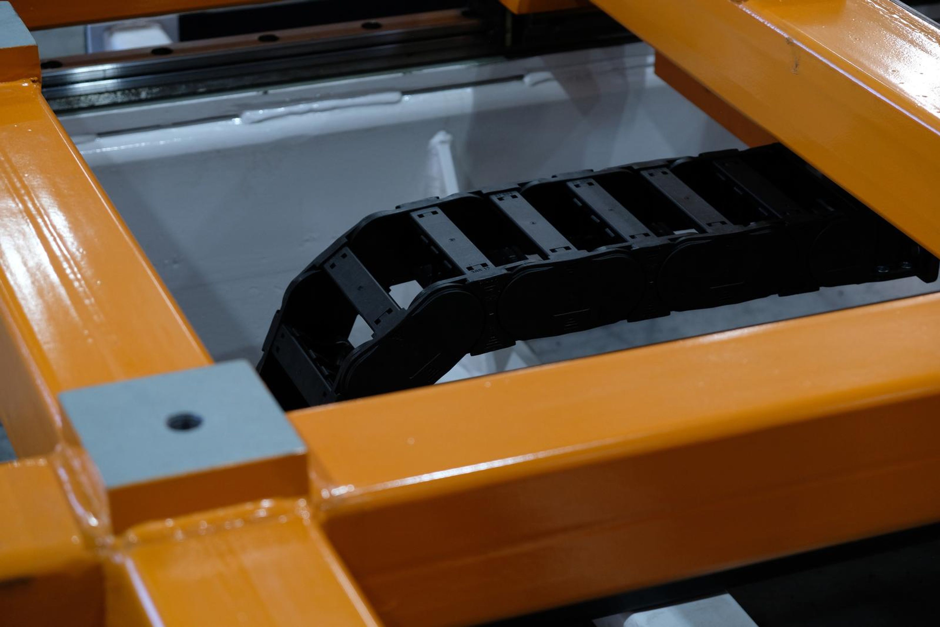 Black cable chain curling beneath an orange frame