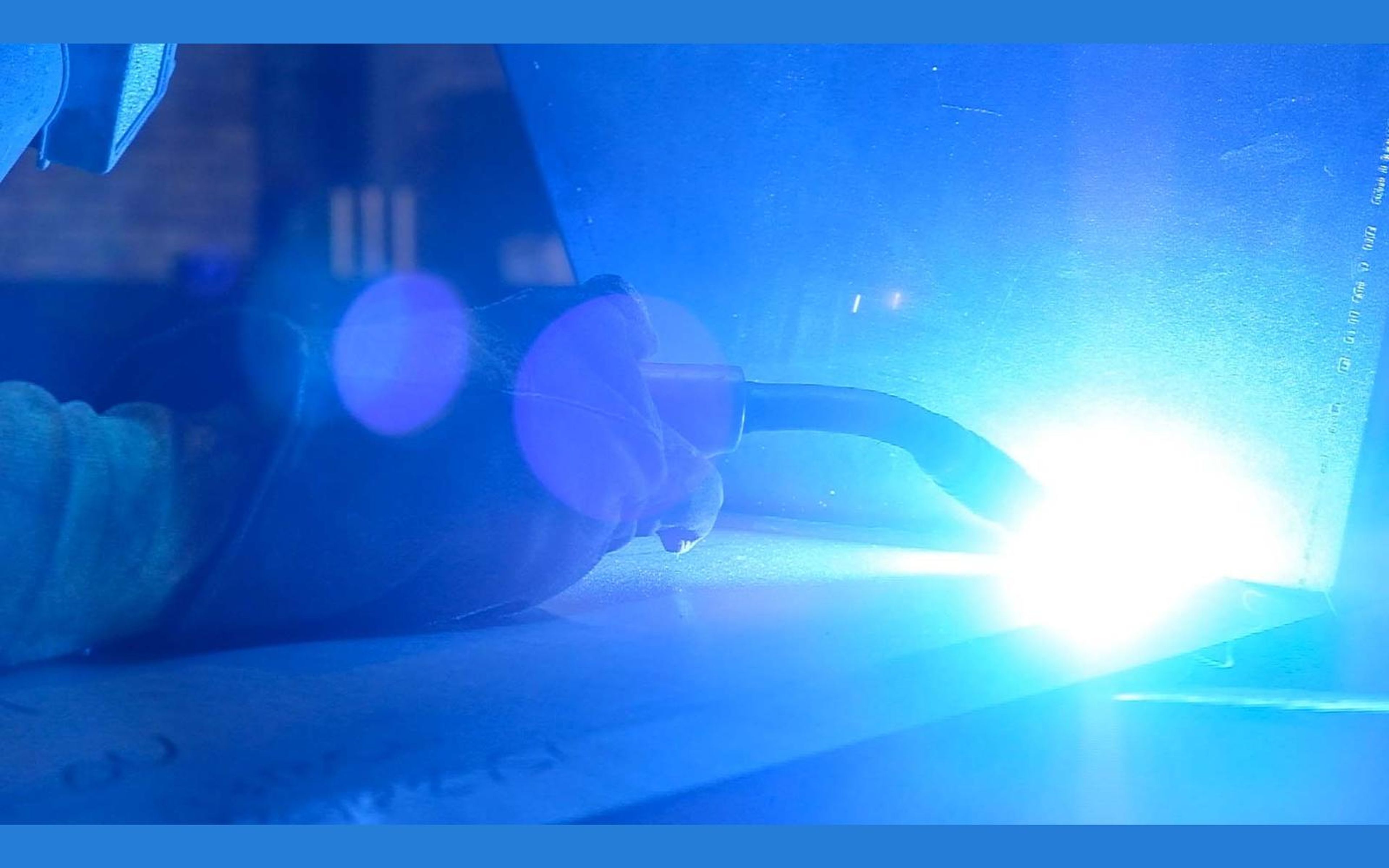 Close view of a welder's torch and glowing weld
