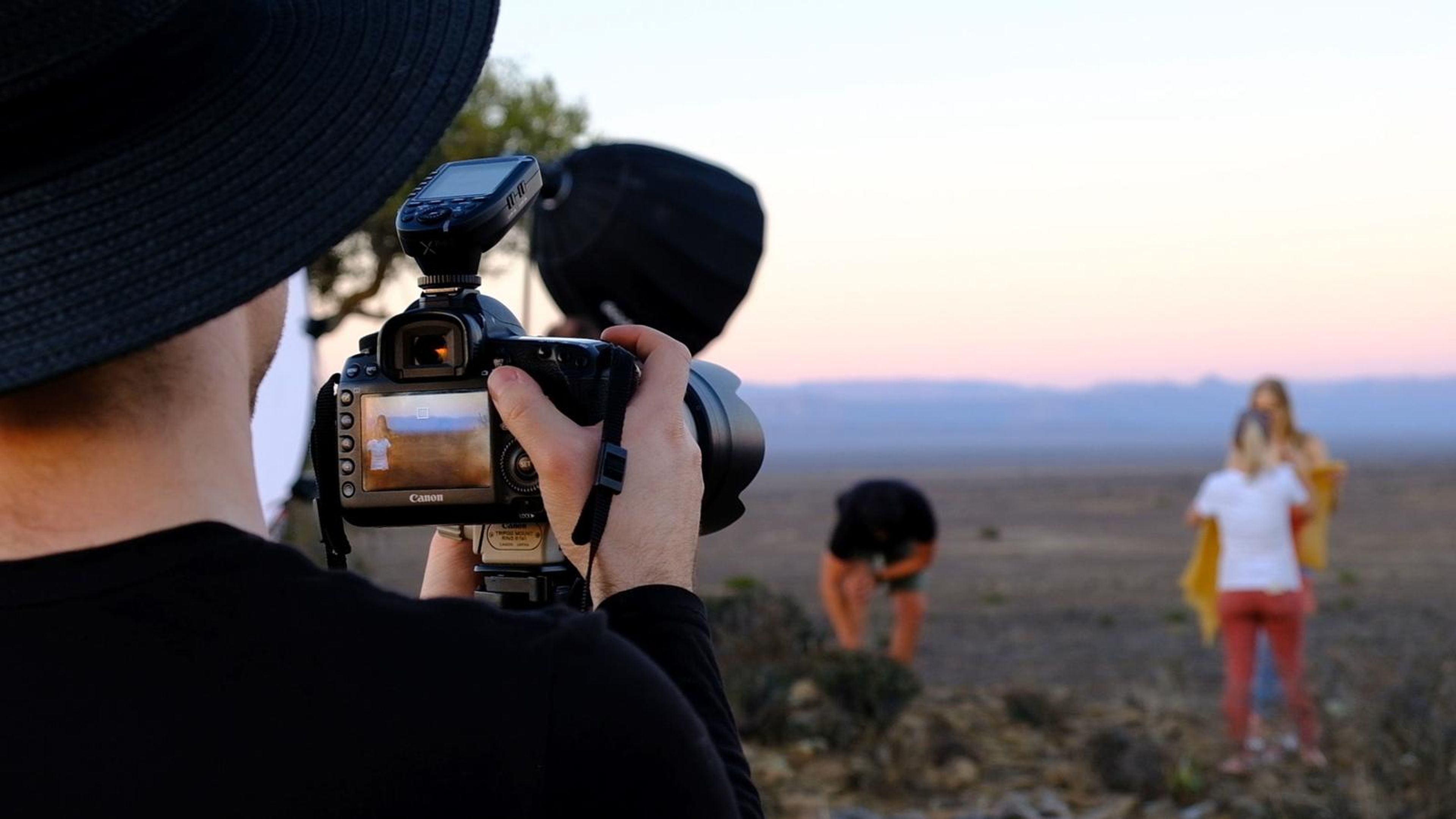 Photographer shooting the model while a stylist crouches nearby
