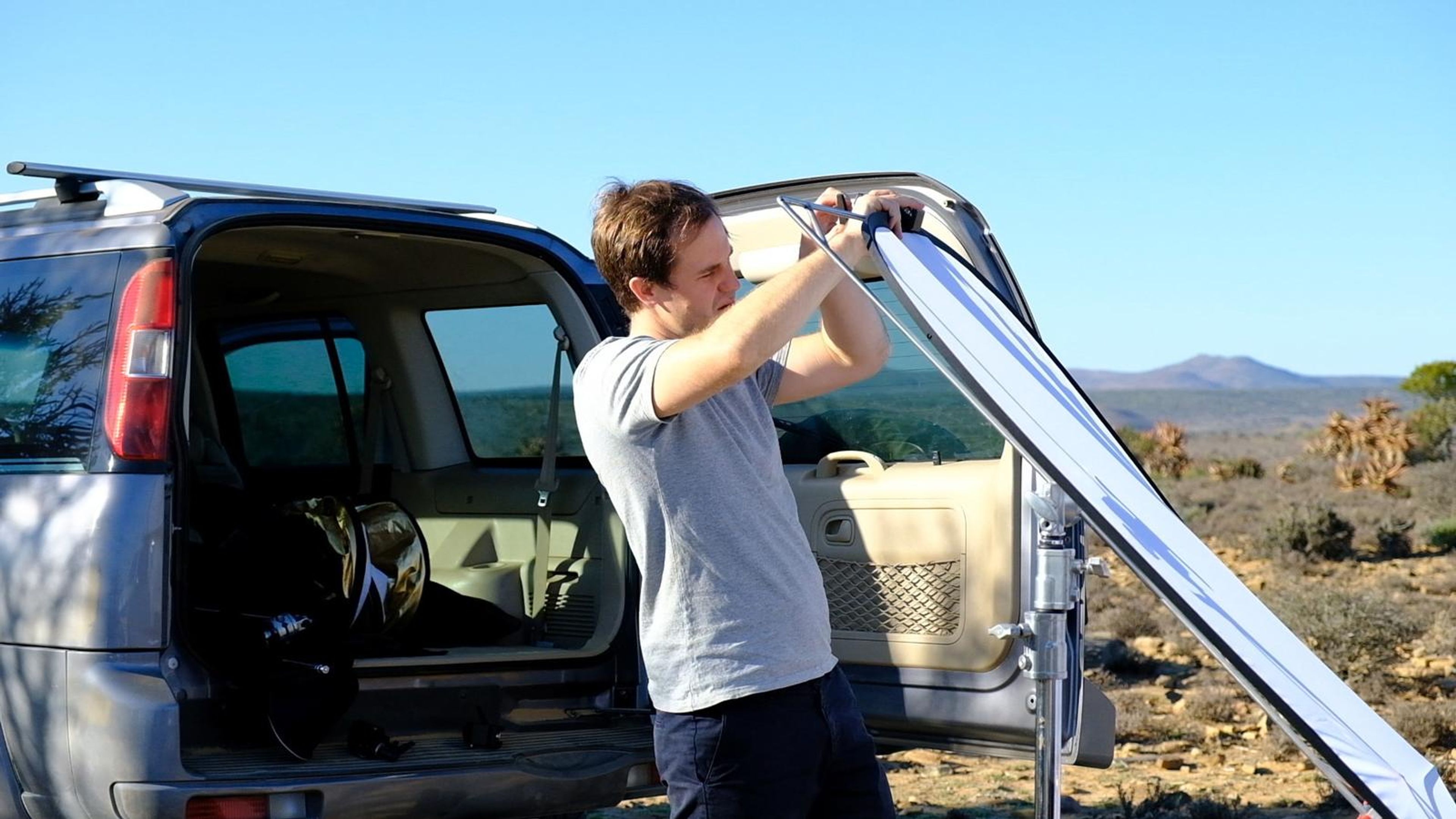 Crew member setting a reflector at the back of a 4x4