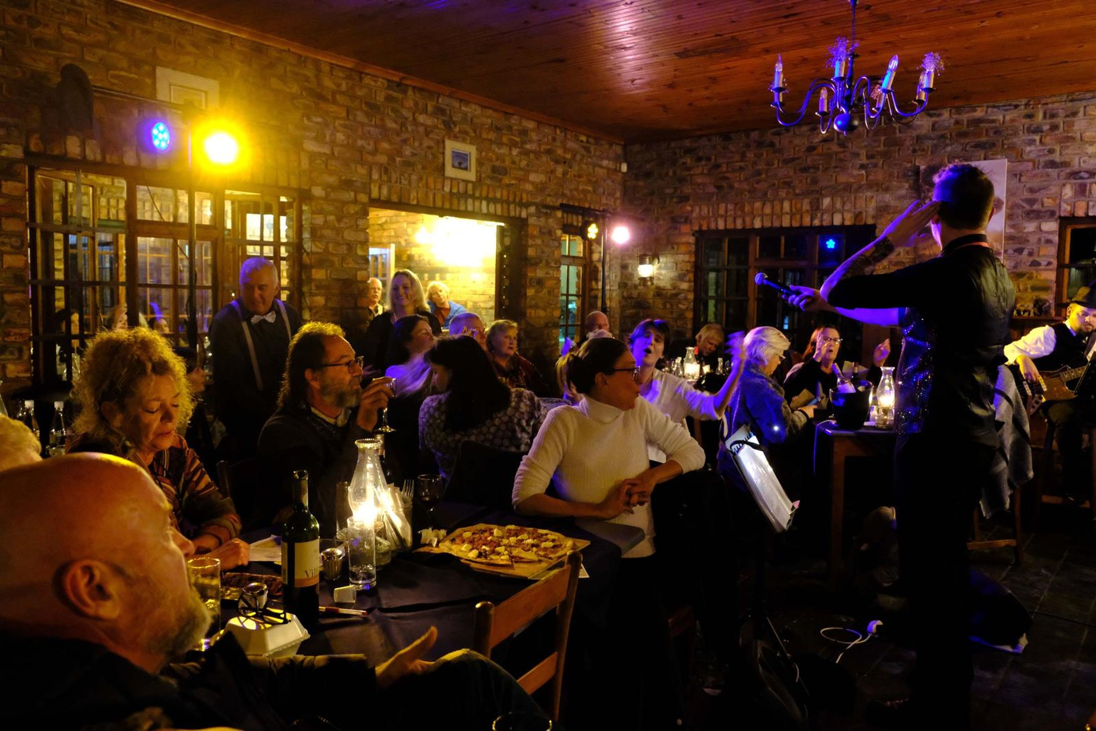 Wide view of a singer working the room, with the band in the background