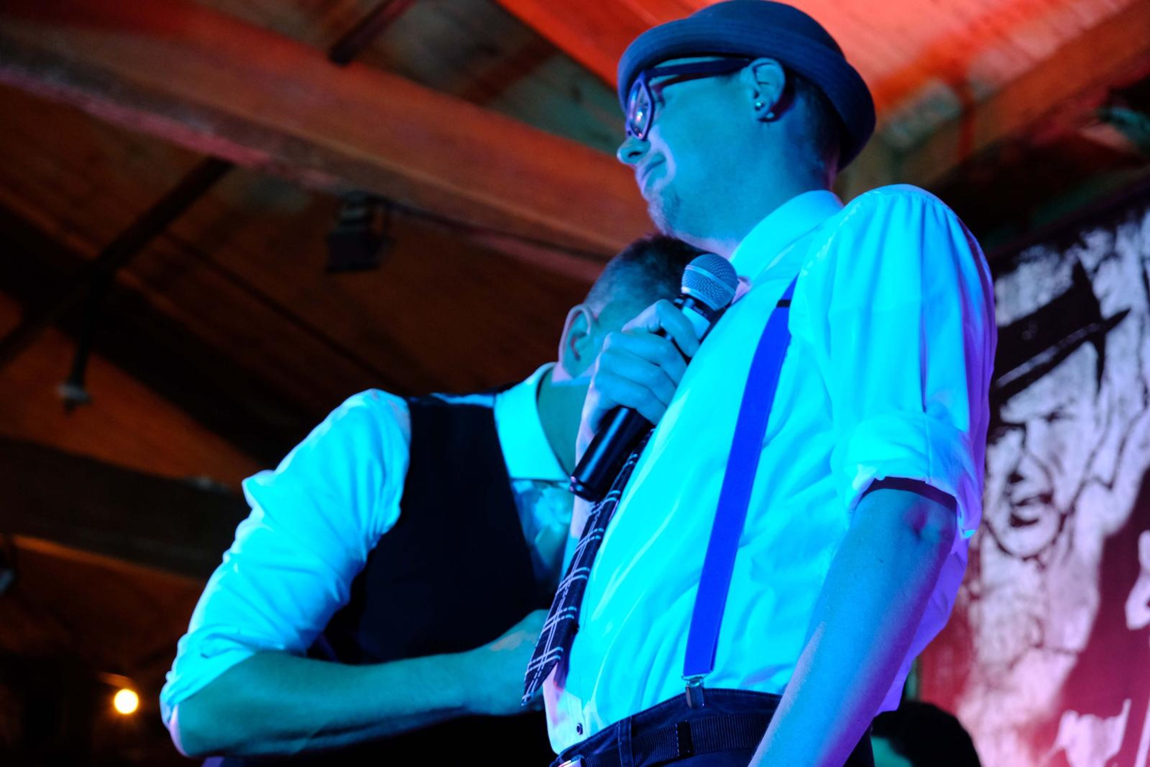 Singers sharing a microphone in blue light