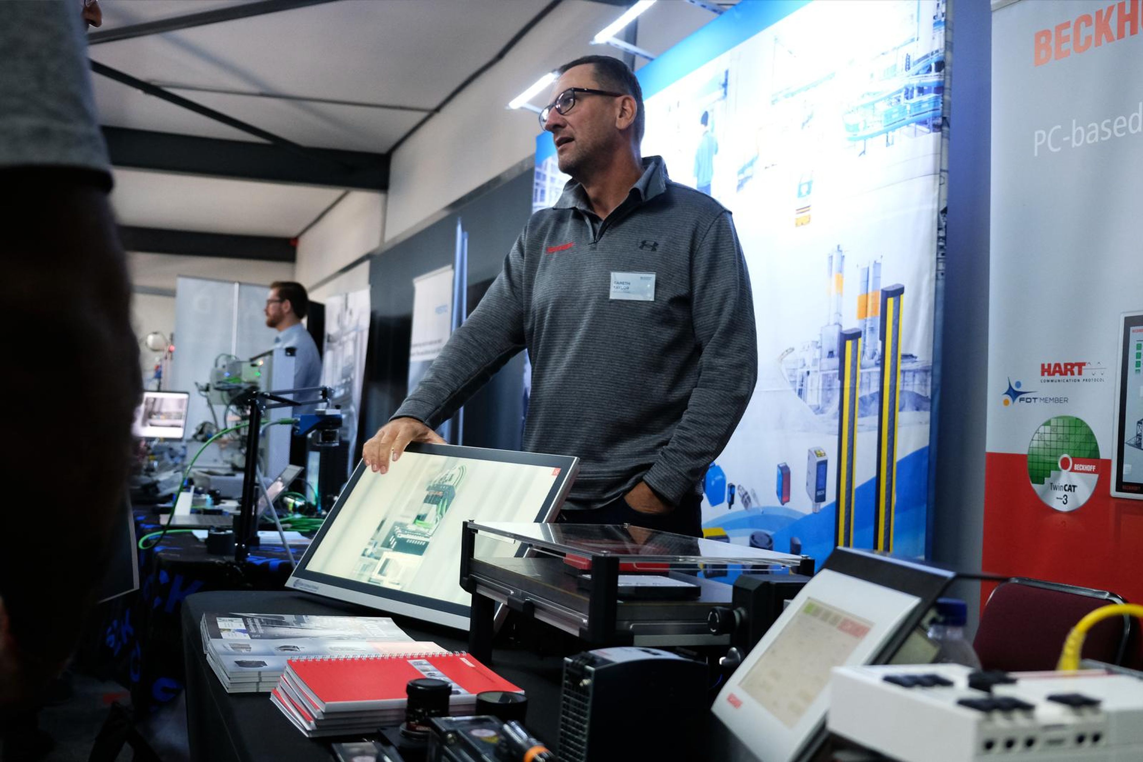 Beckhoff presenter at his stand beside a touchscreen panel