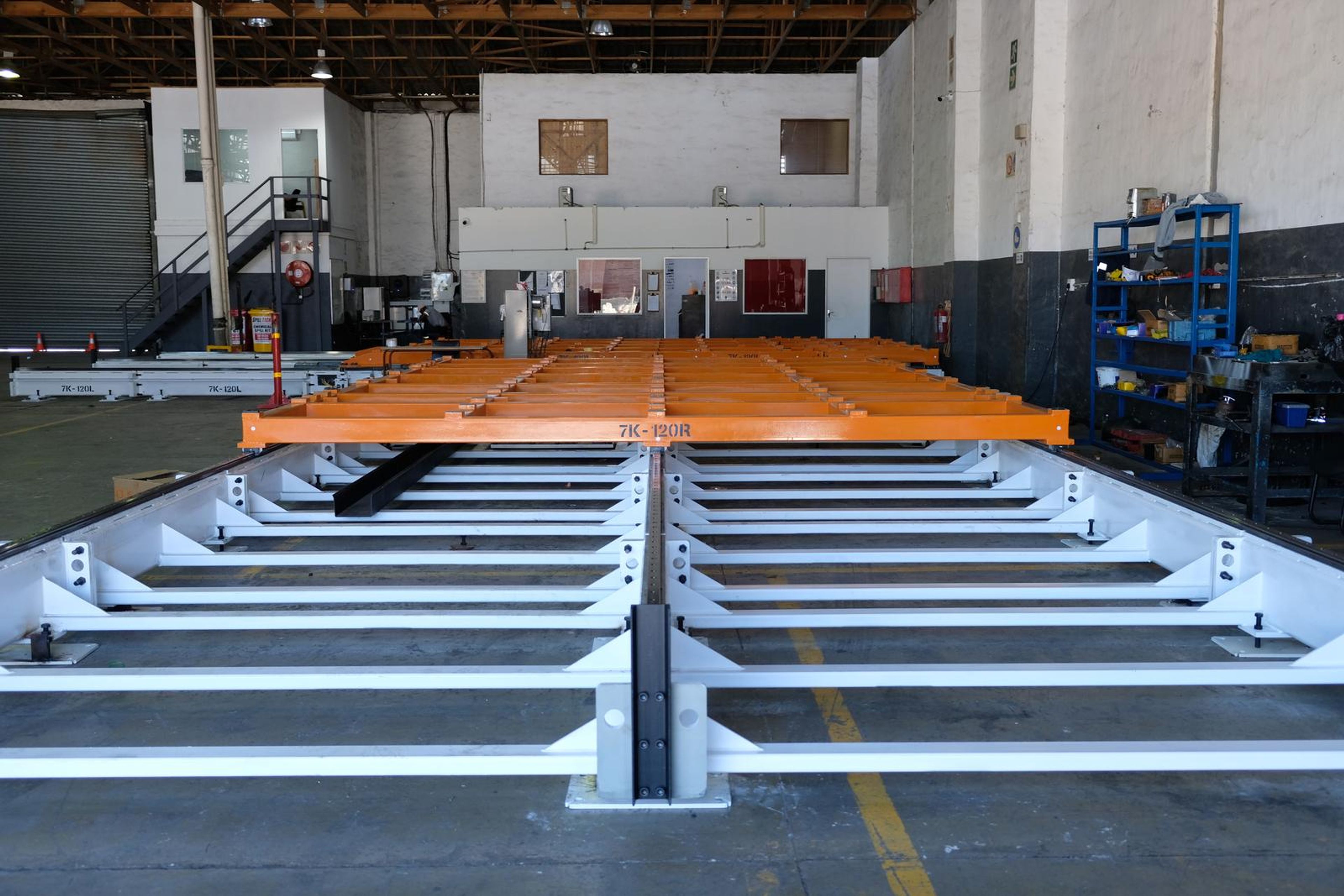 Wide view of the white base frame running the length of the plant bay