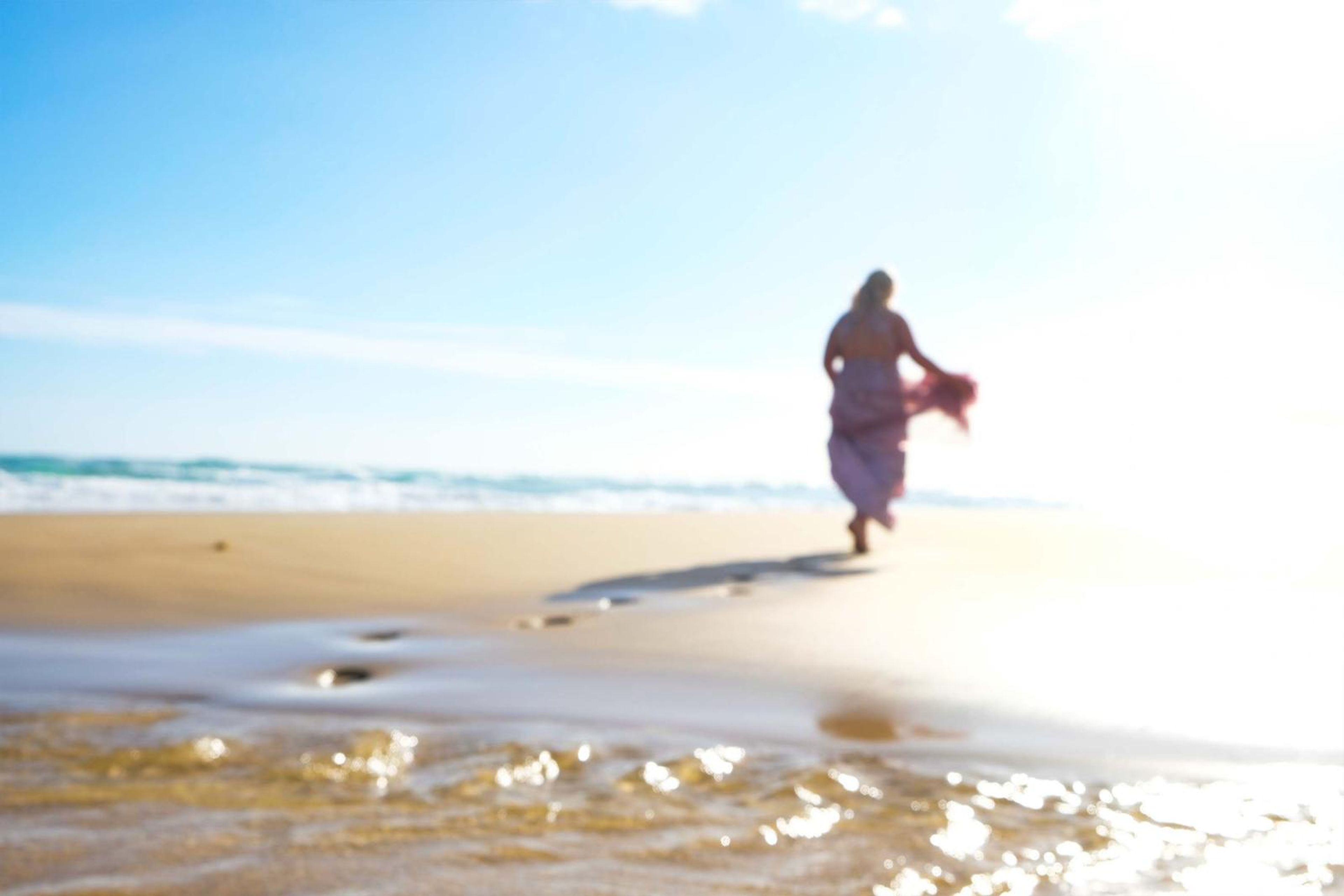 Running along the wet sand towards the sun