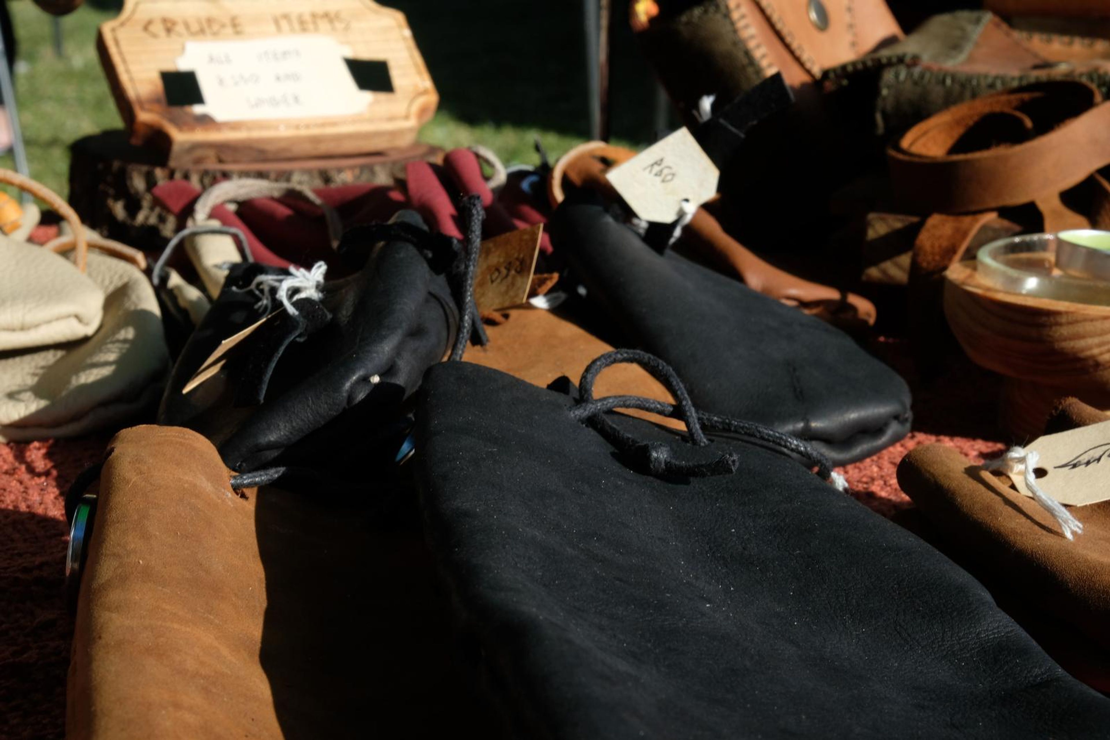 Black and tan leather pouches with handwritten tags on the table