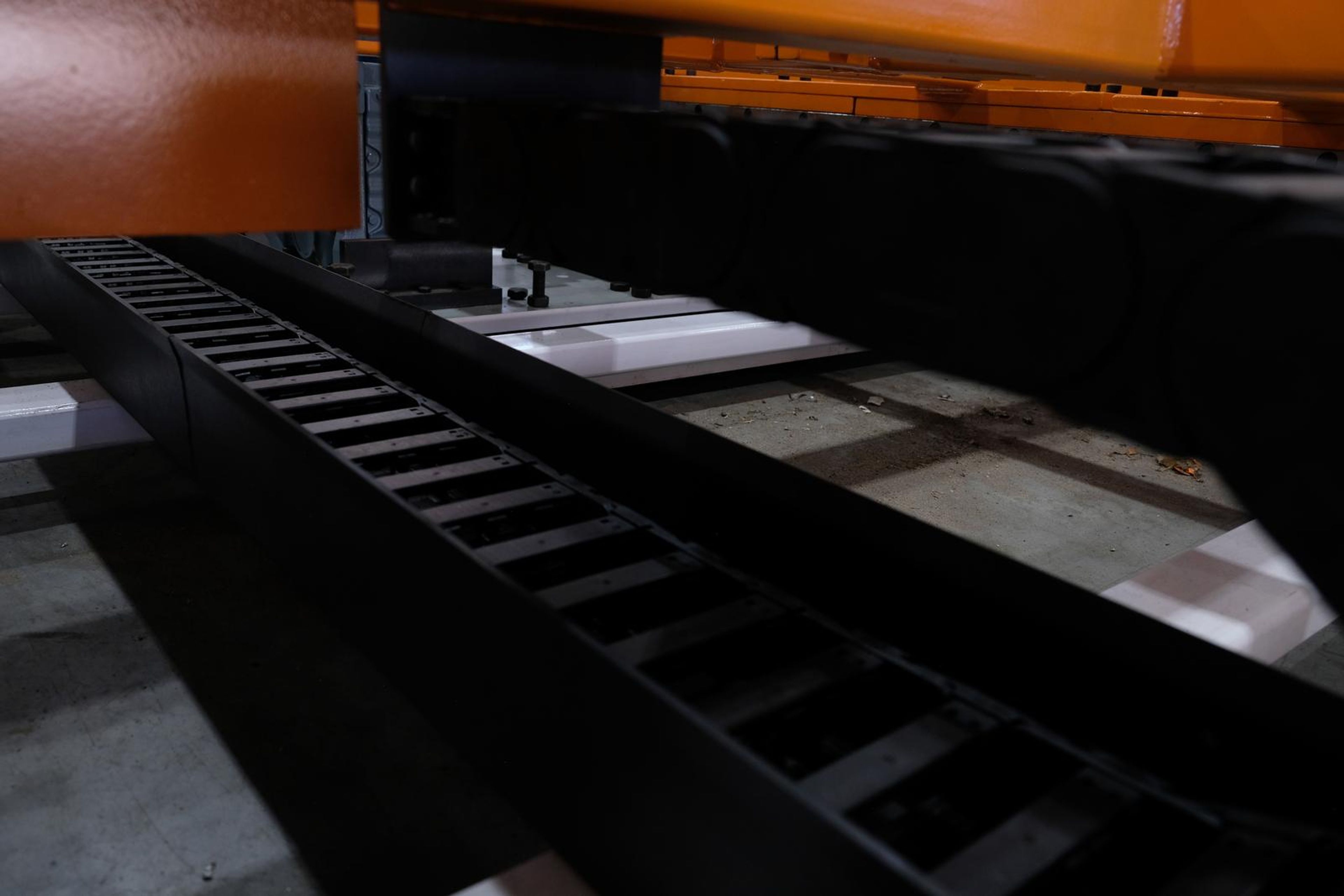 Black cable chain running beneath an orange beam