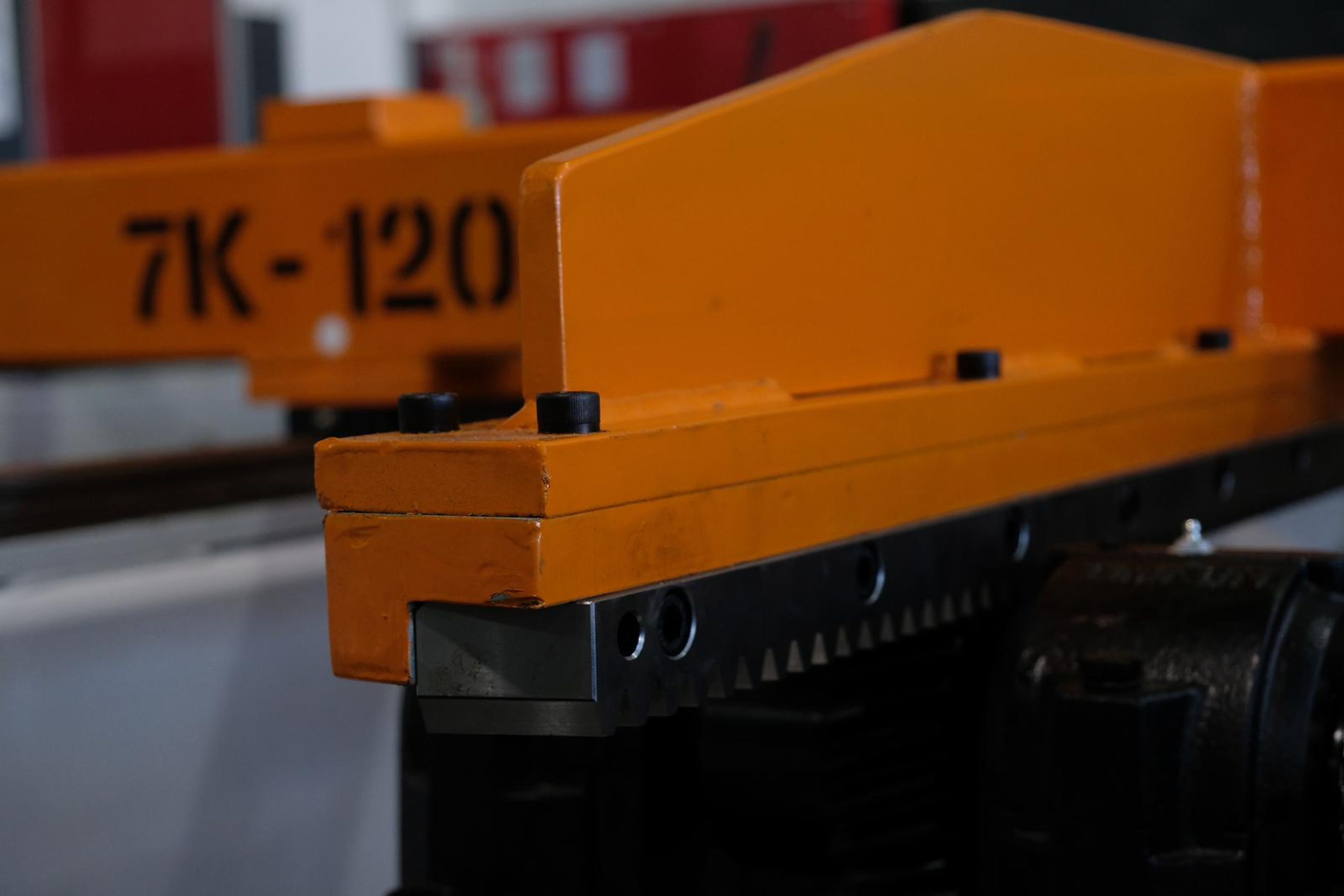 Close view of an orange carriage stencilled 7K-120 on a drive rail