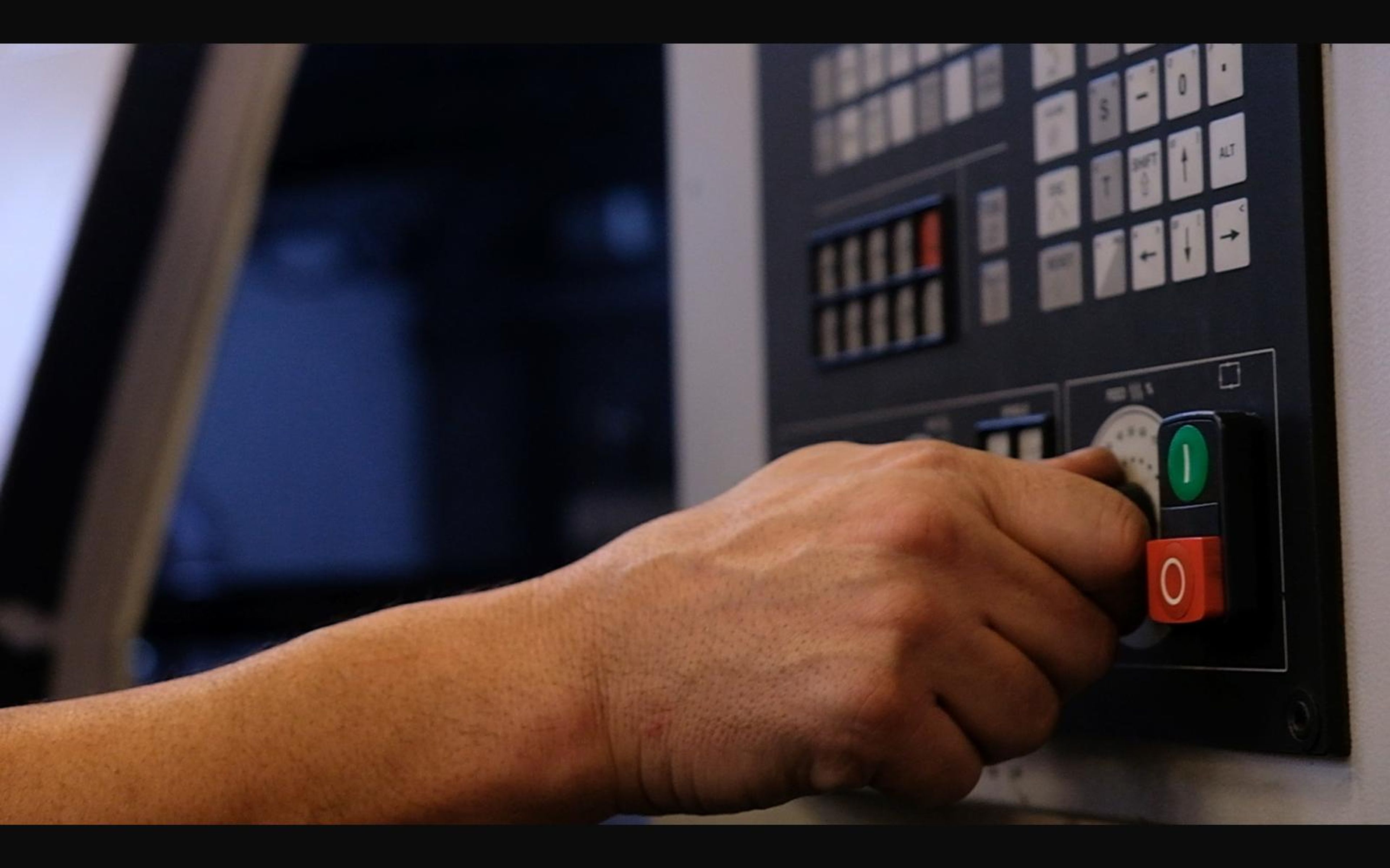Hand pressing a lathe control button