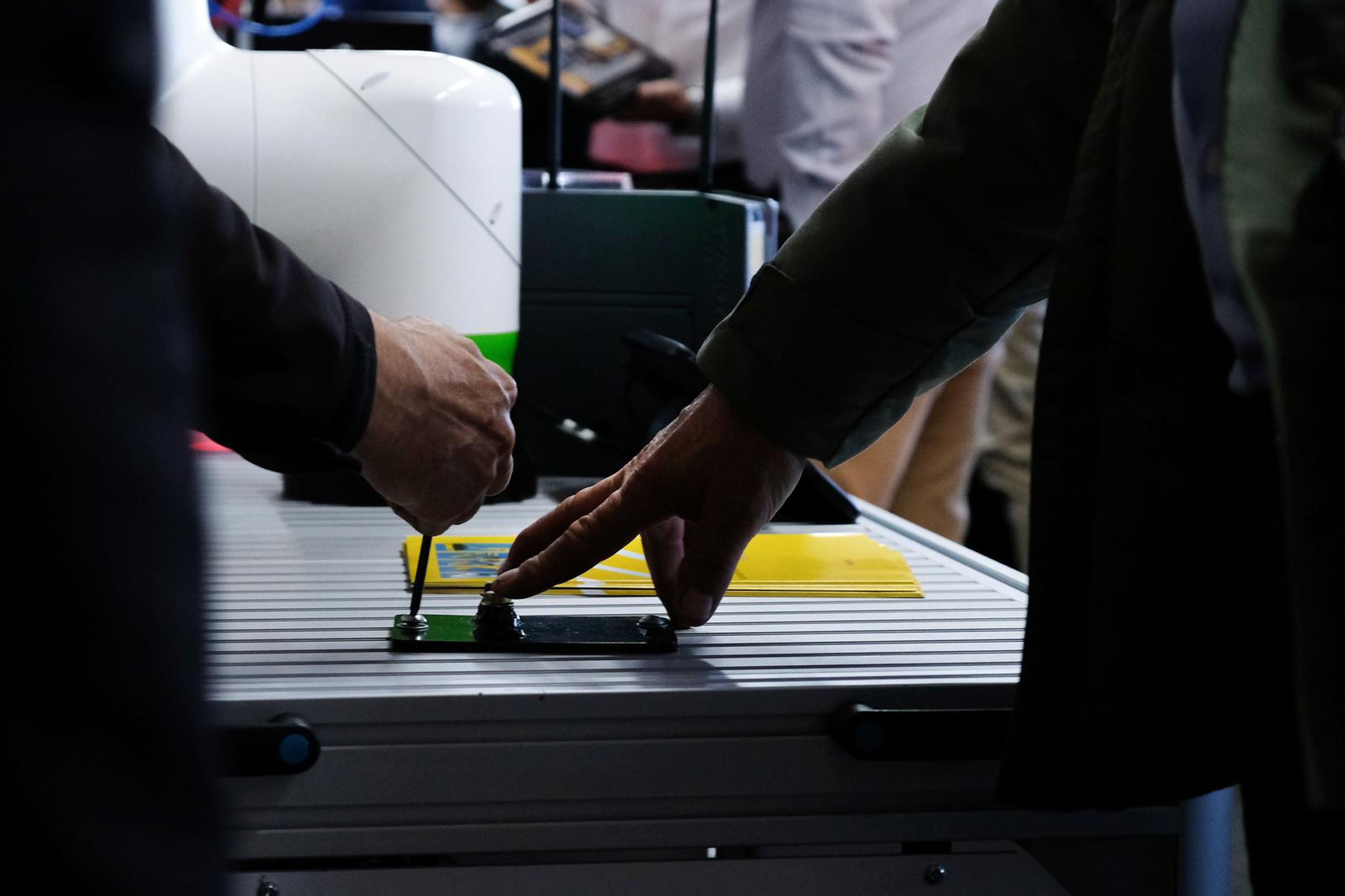 Hands adjusting a part on the Fanuc demonstration bench