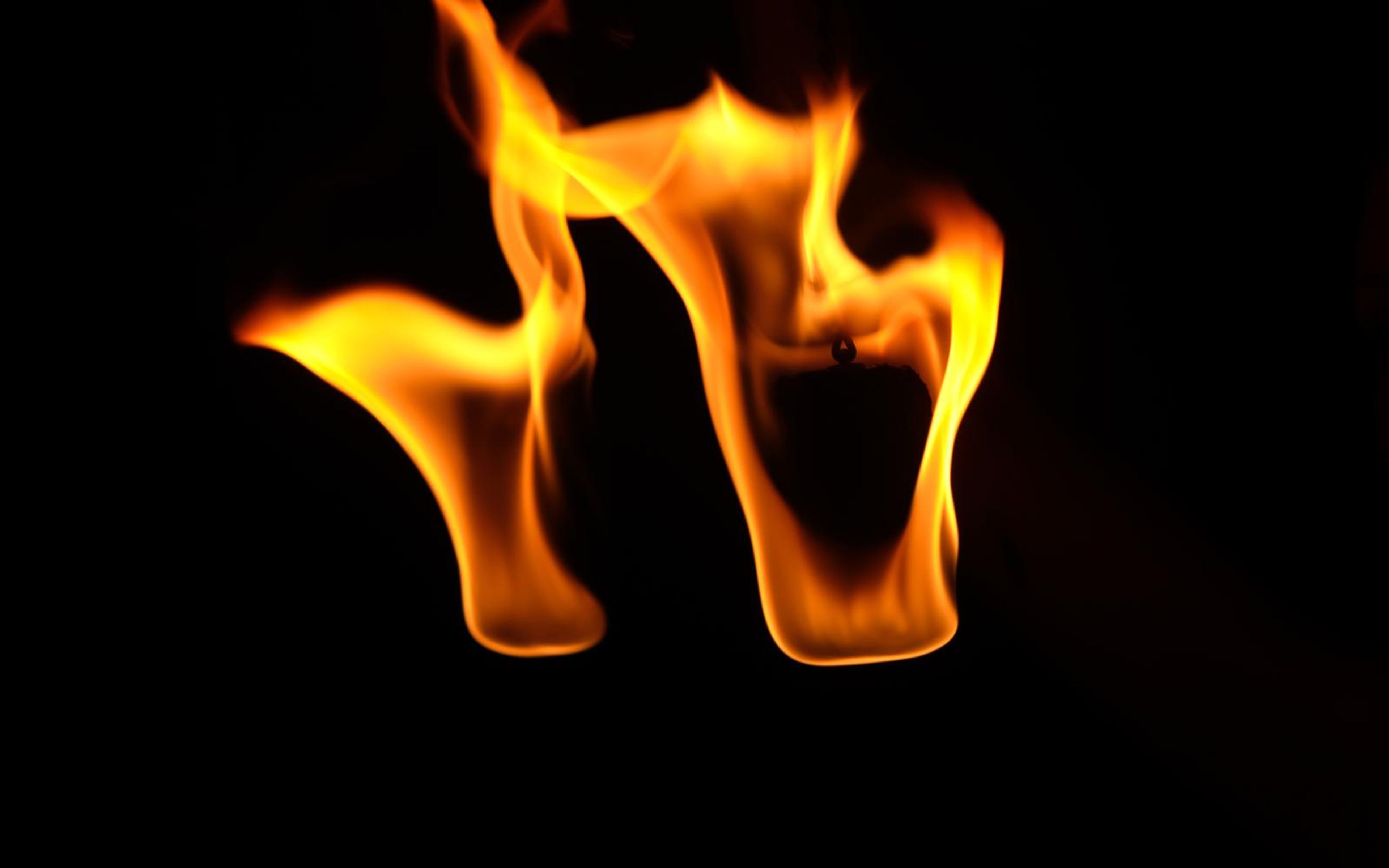 Two broad flames arching over a gap in the middle of the frame
