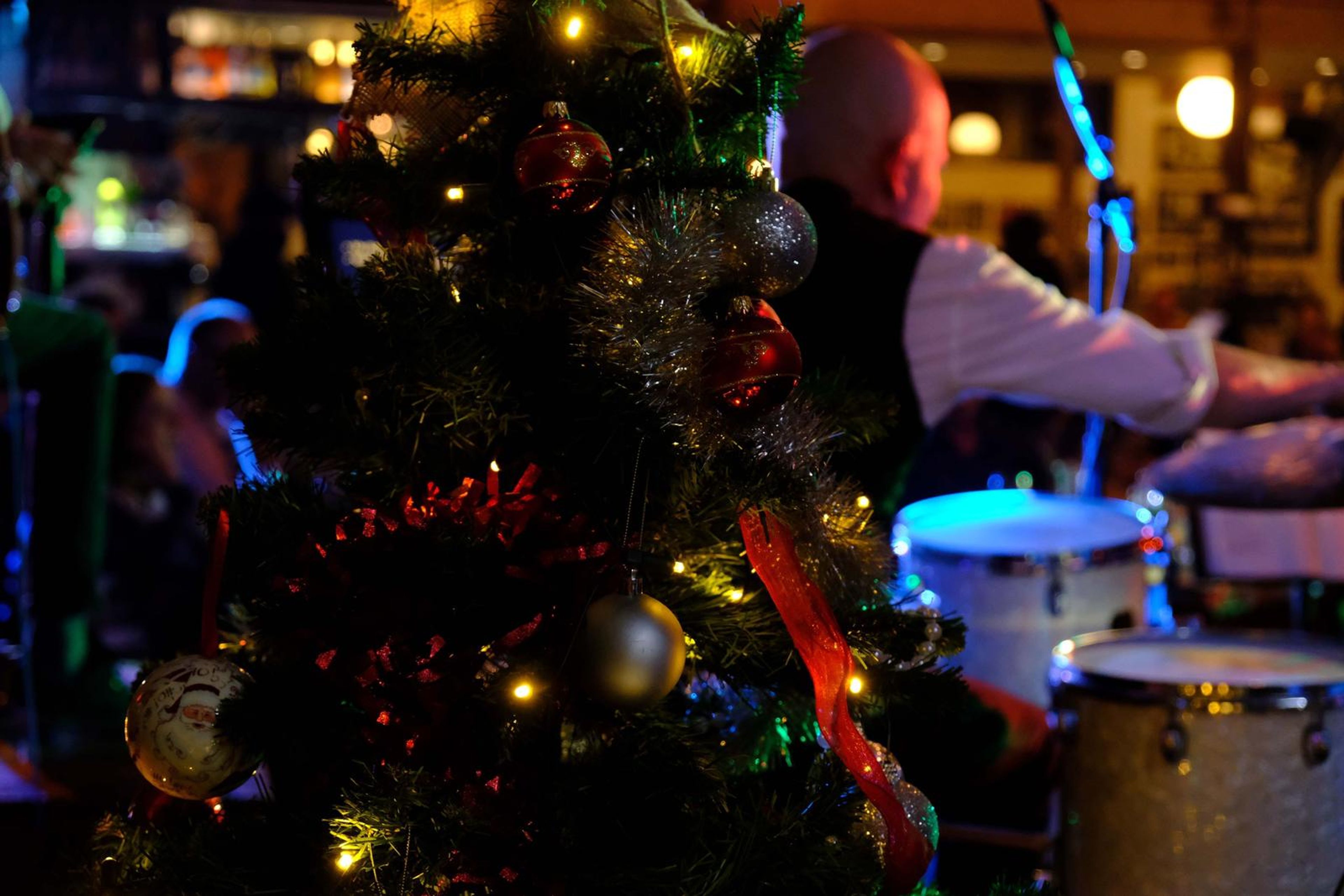 Christmas tree in front of the drummer playing a white kit