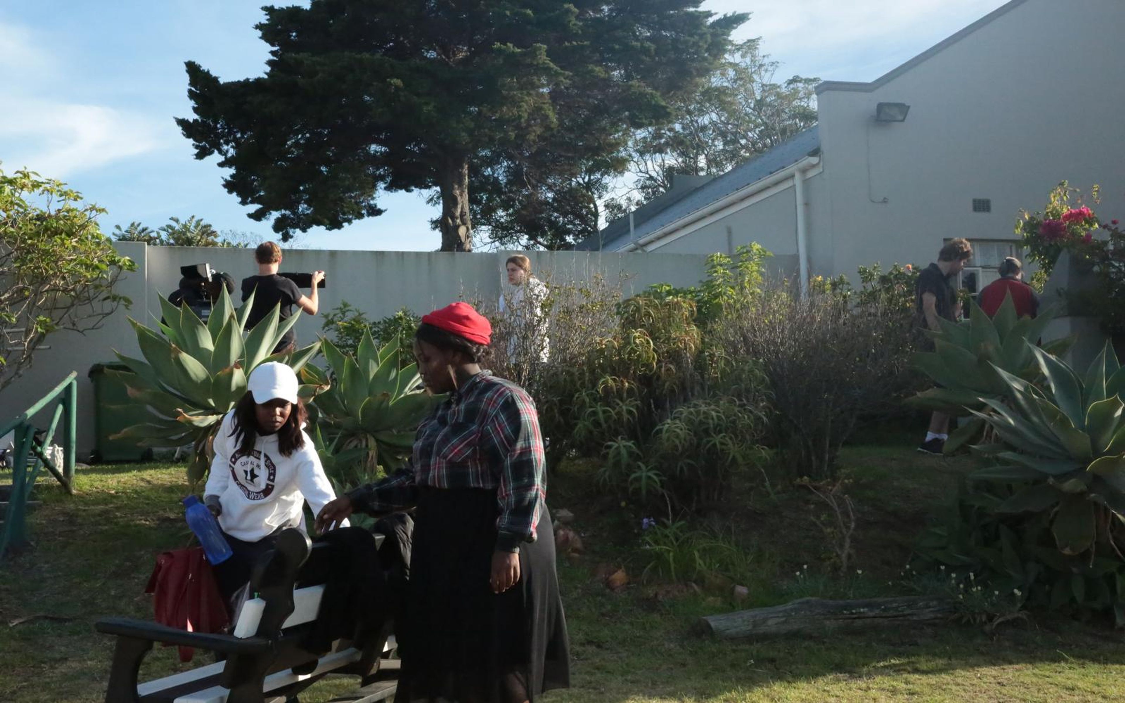 Sunlit garden location with crew setting up a camera and boom pole beside an agave plant