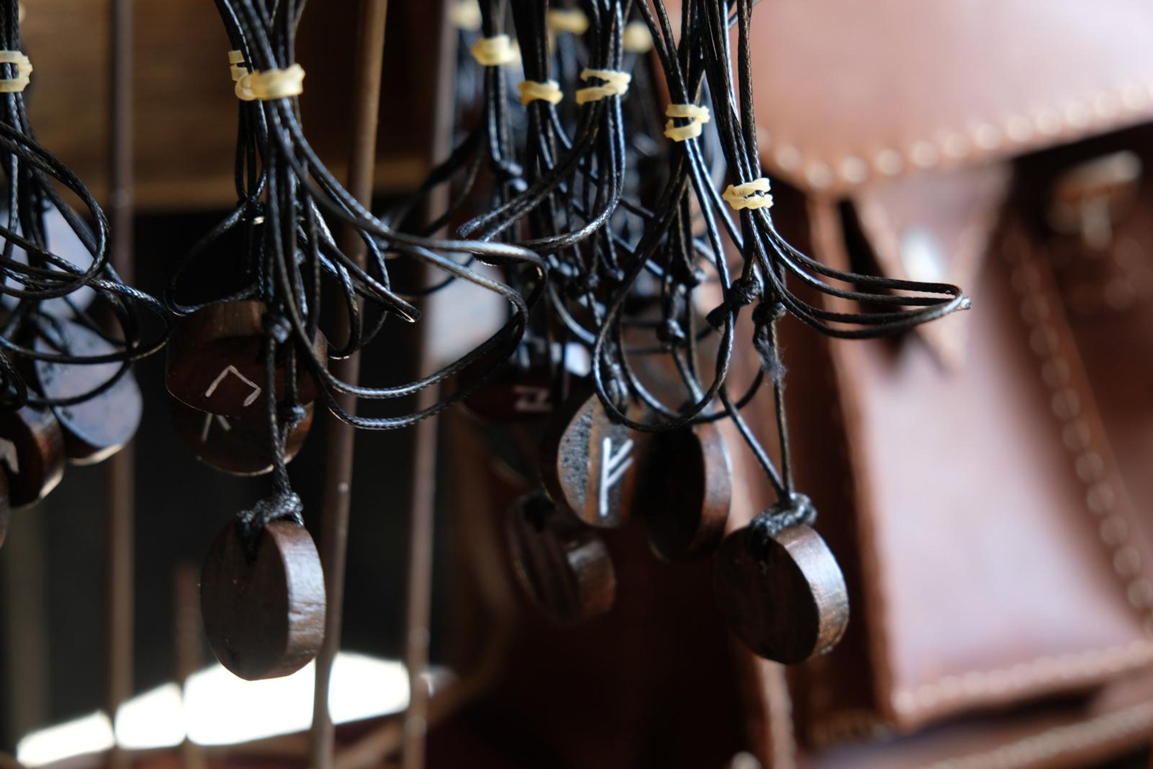Leather cord pendants hanging beside a brown leather satchel