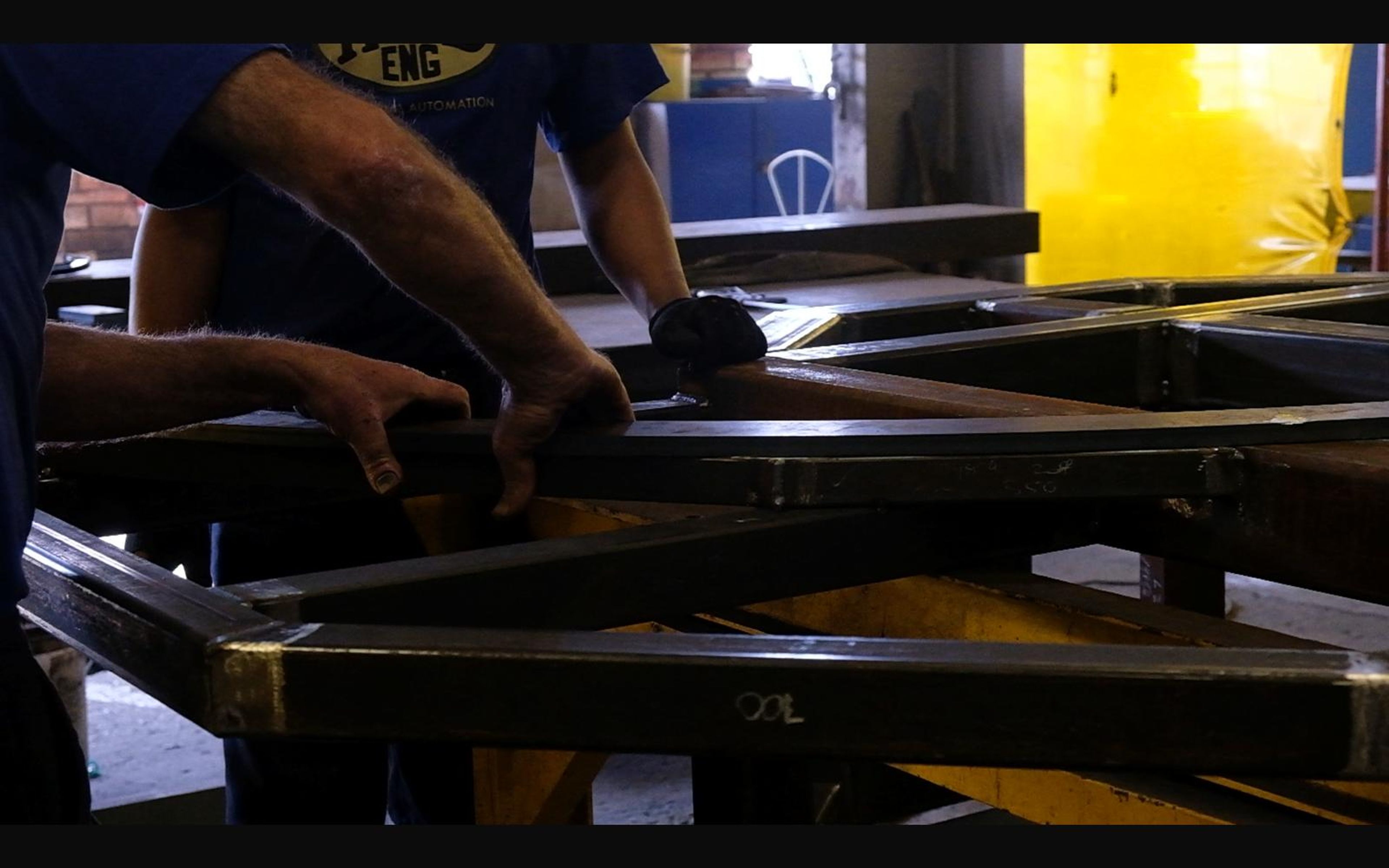 Hands assembling a steel frame