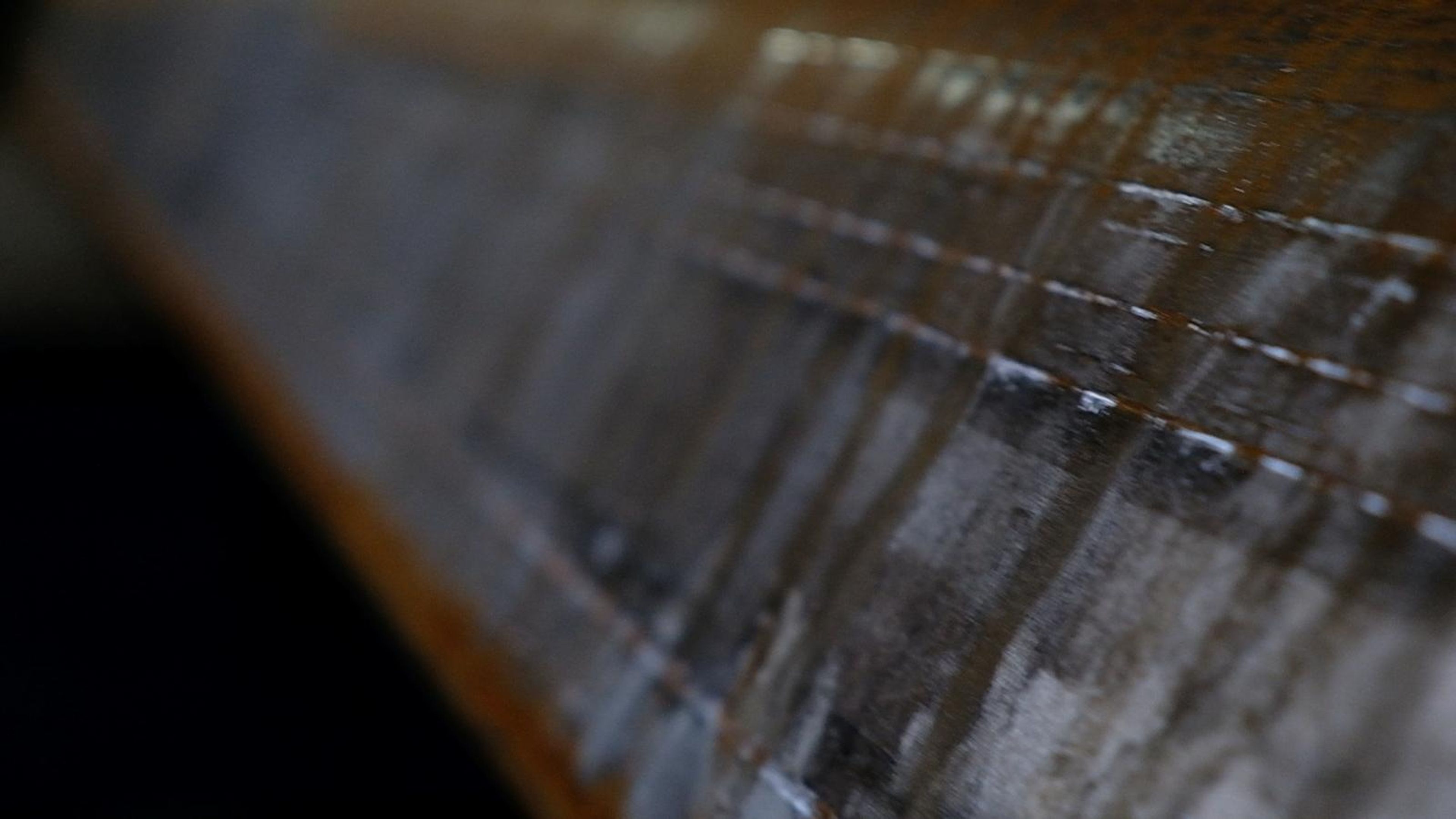 Close view of a rusted steel plate edge in soft focus