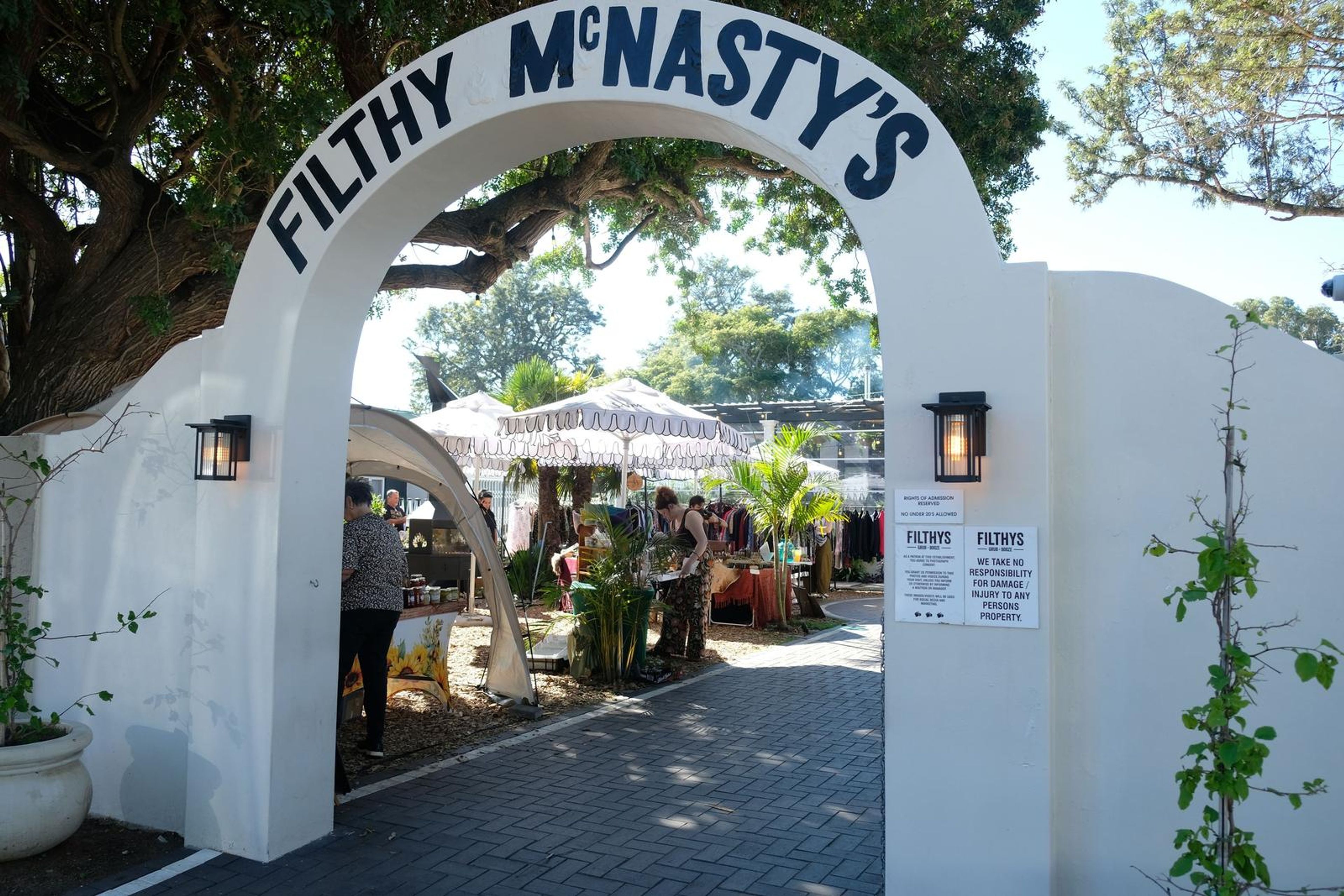Juuks stall under a palm tree at Filthy McNasty's market