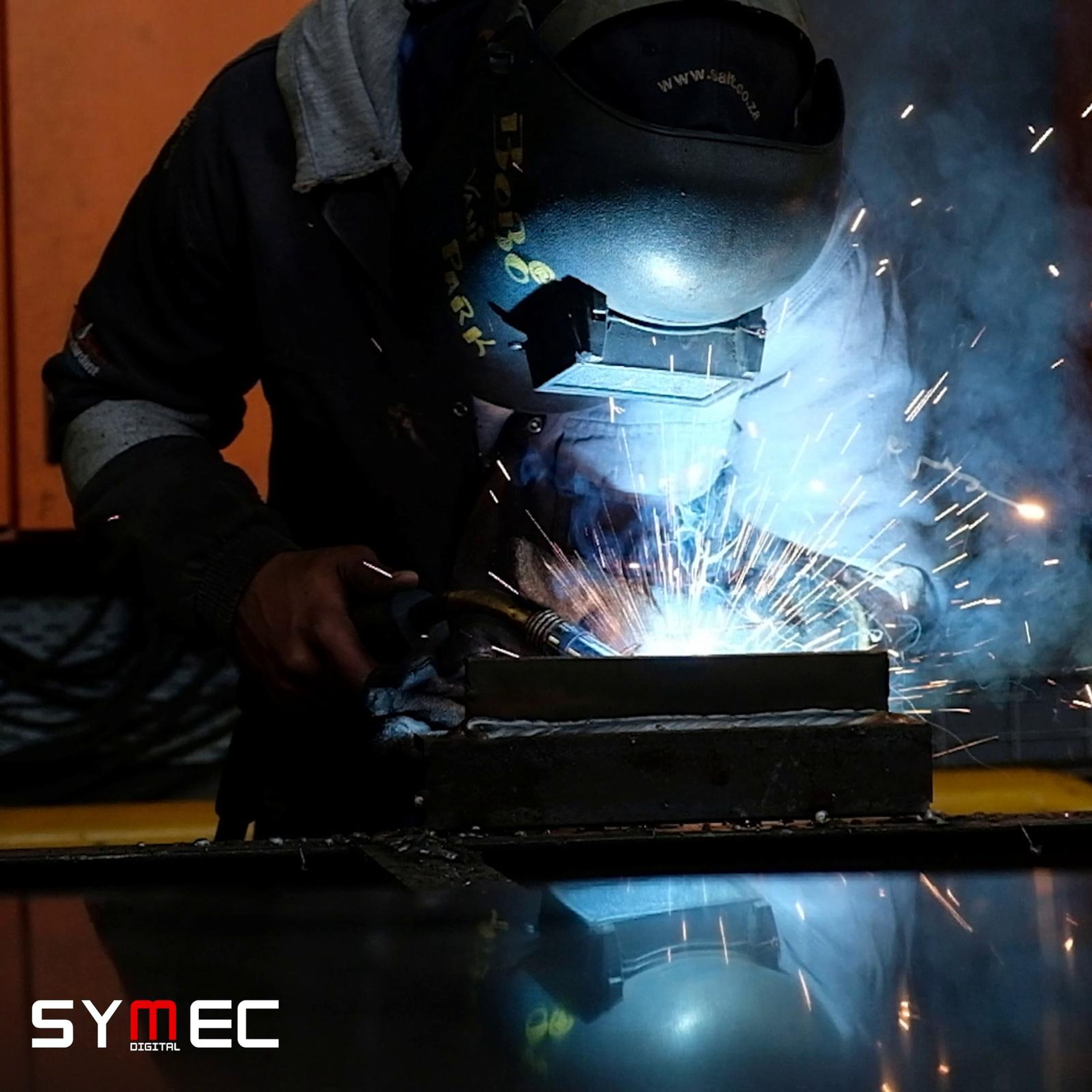 Square cut of a welder in a mask with sparks