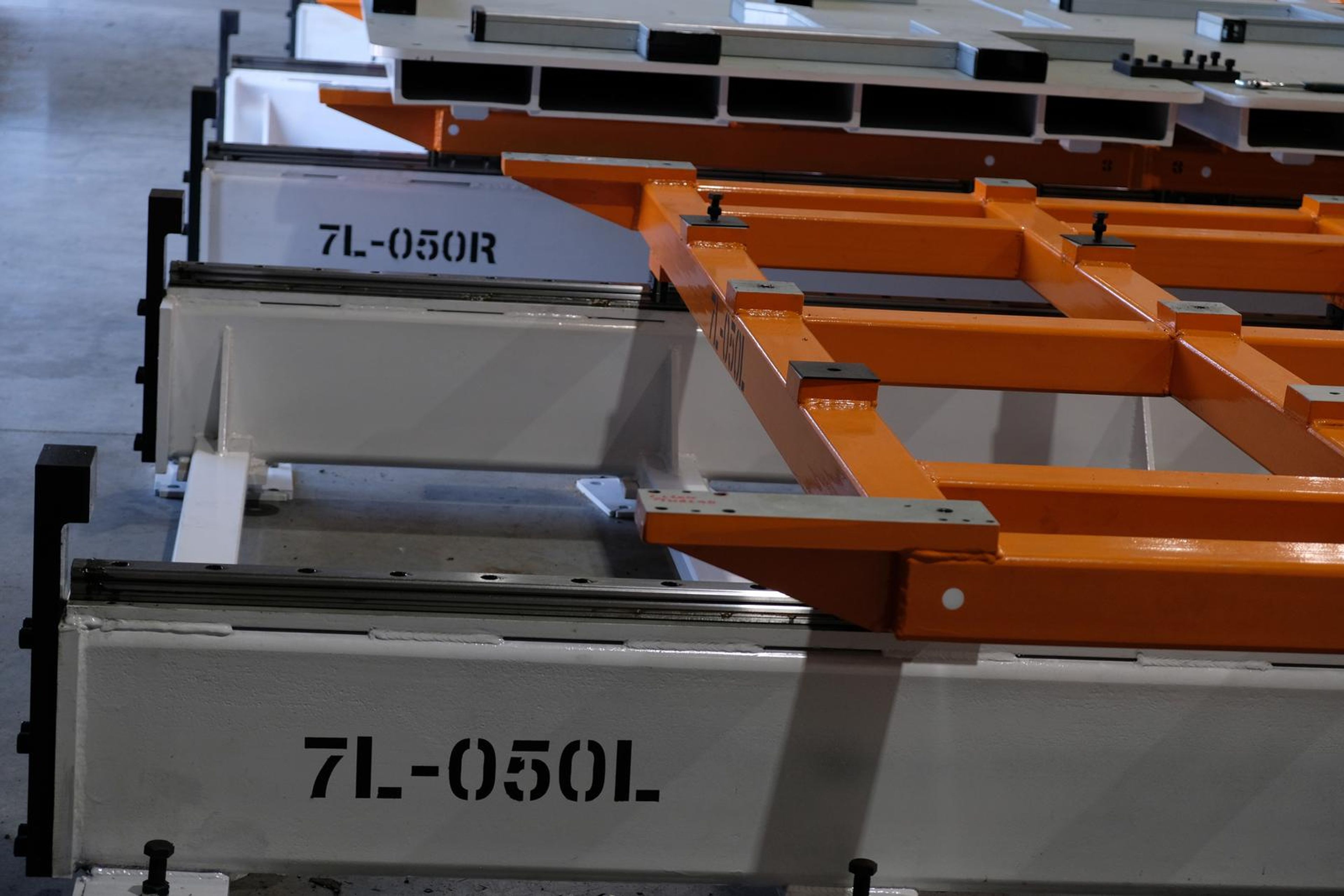 White steel girder stencilled 7L-050L beside an orange frame