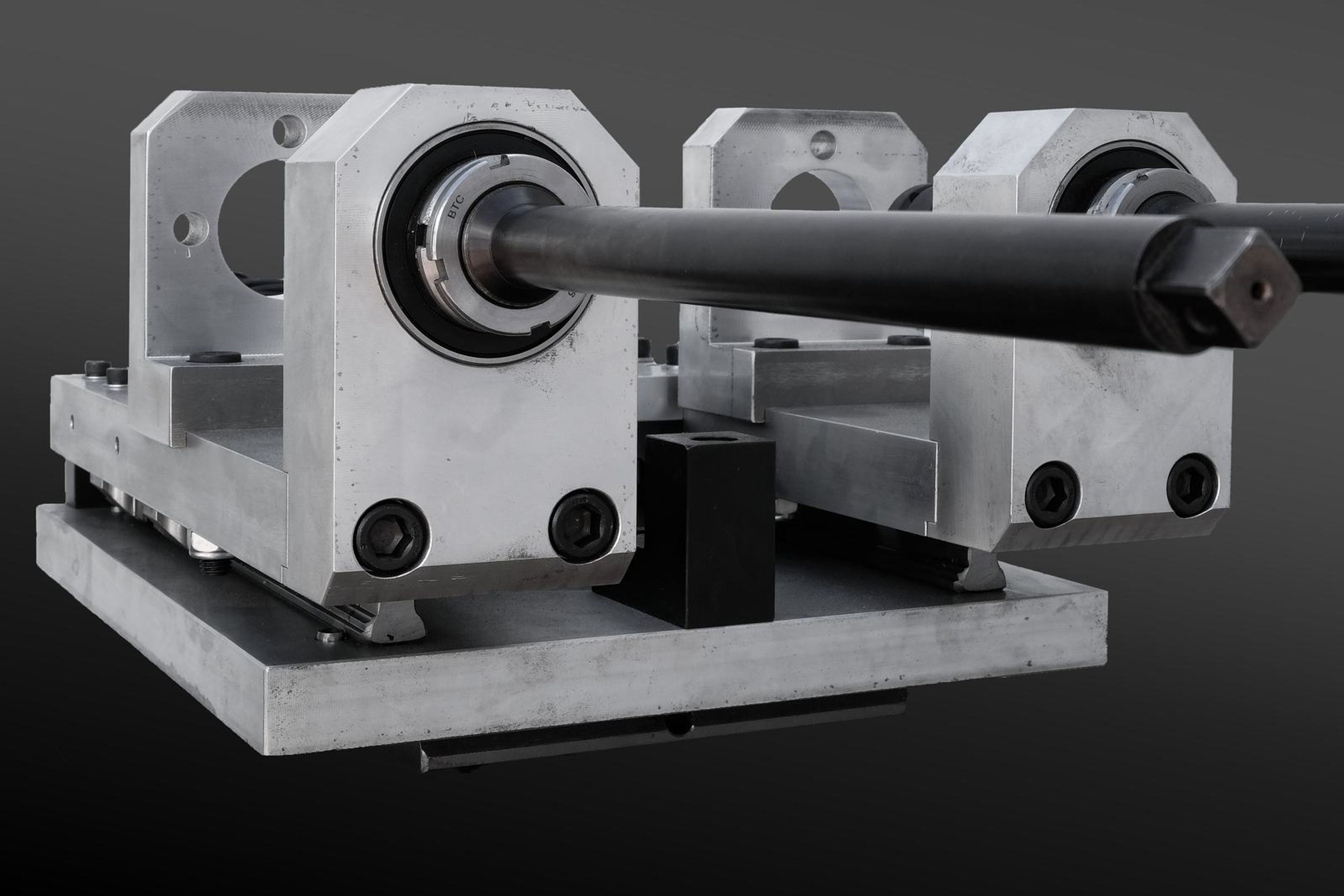 Bolting tool on a plain studio background, medium view of the bearing housings and shaft