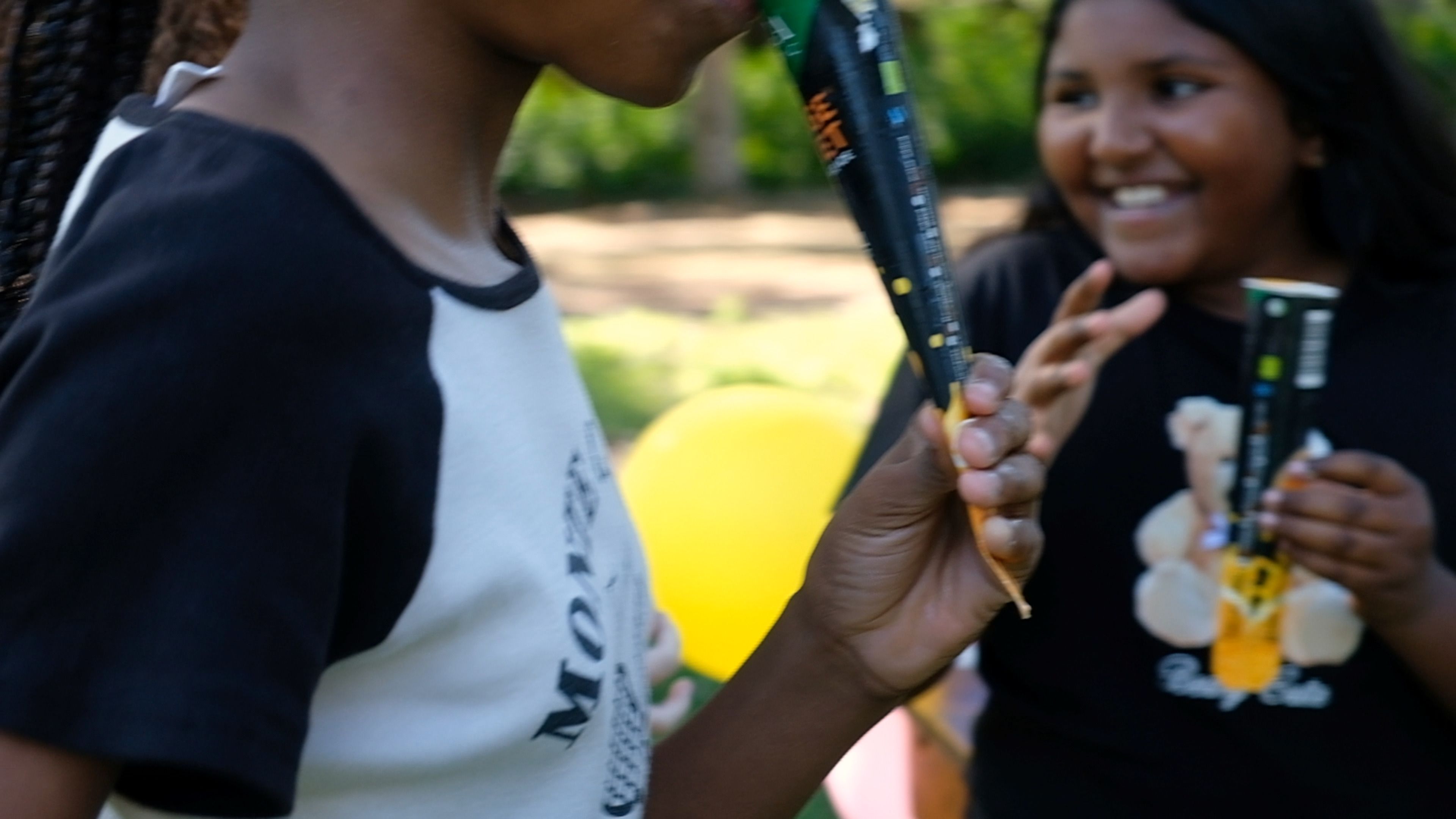 Children laughing while holding Orange Rocket ice tubes