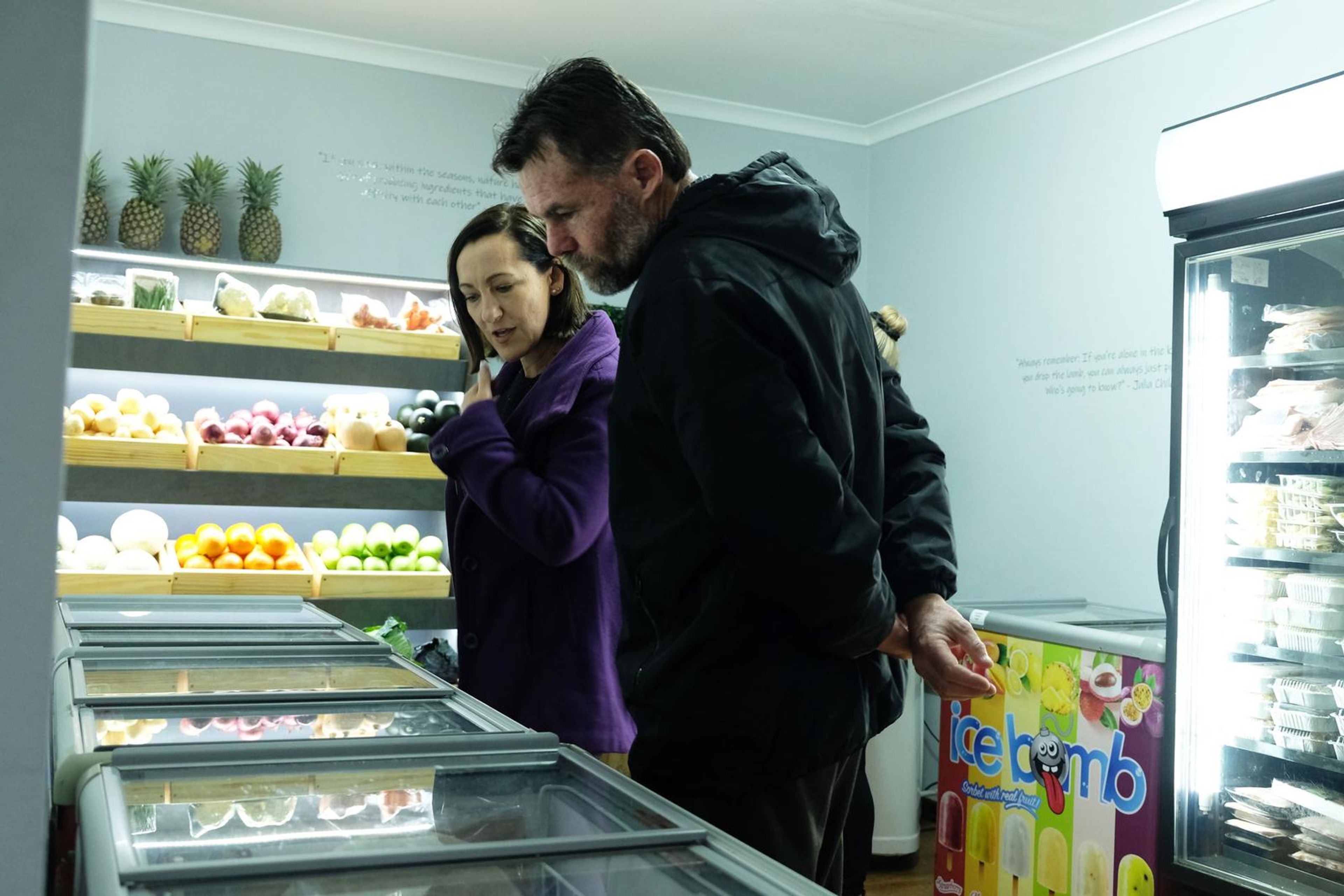 Two guests browsing the fresh fruit display and freezers at the Chef's Larder