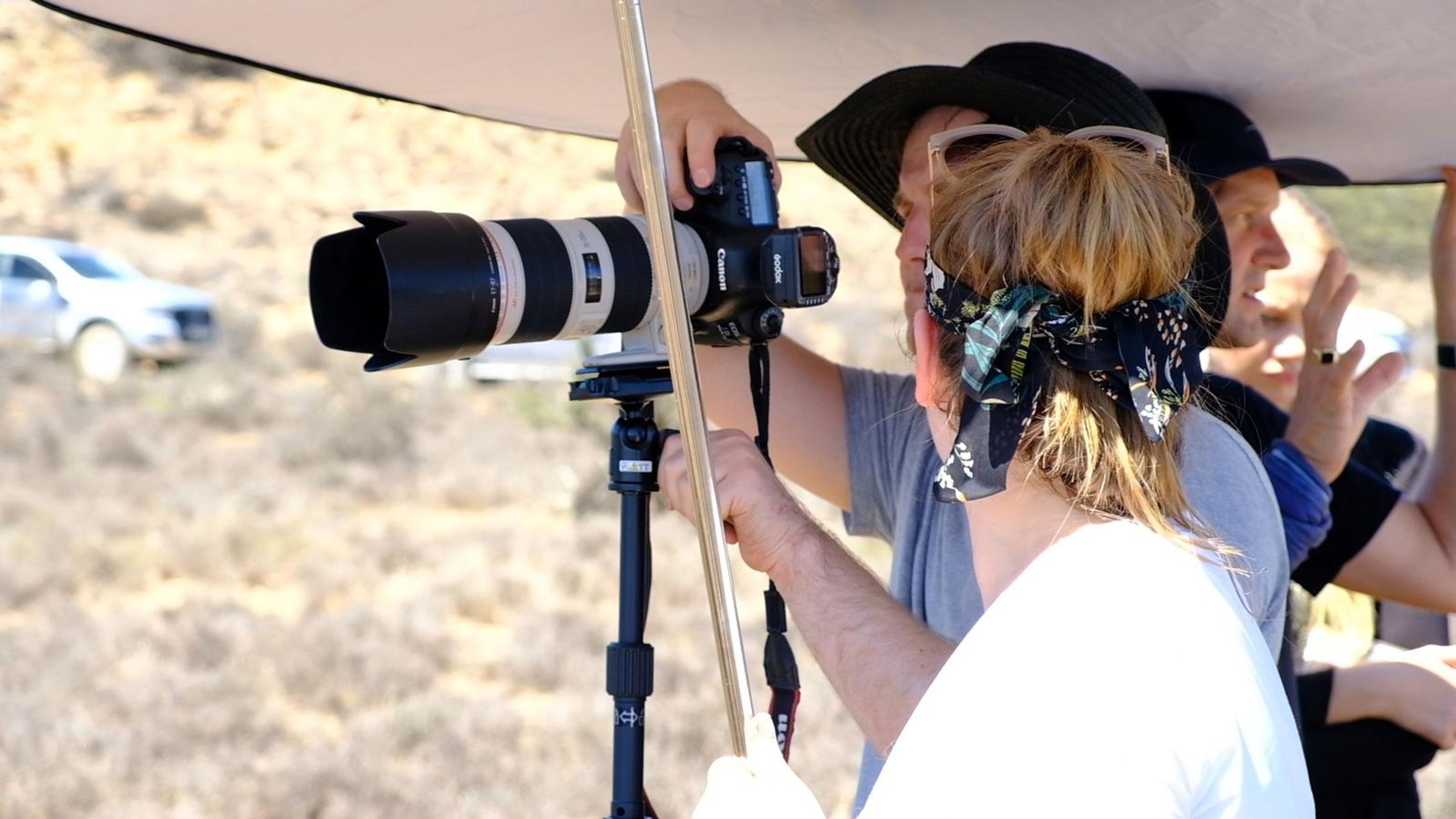 Photographer and assistant working under a reflector canopy