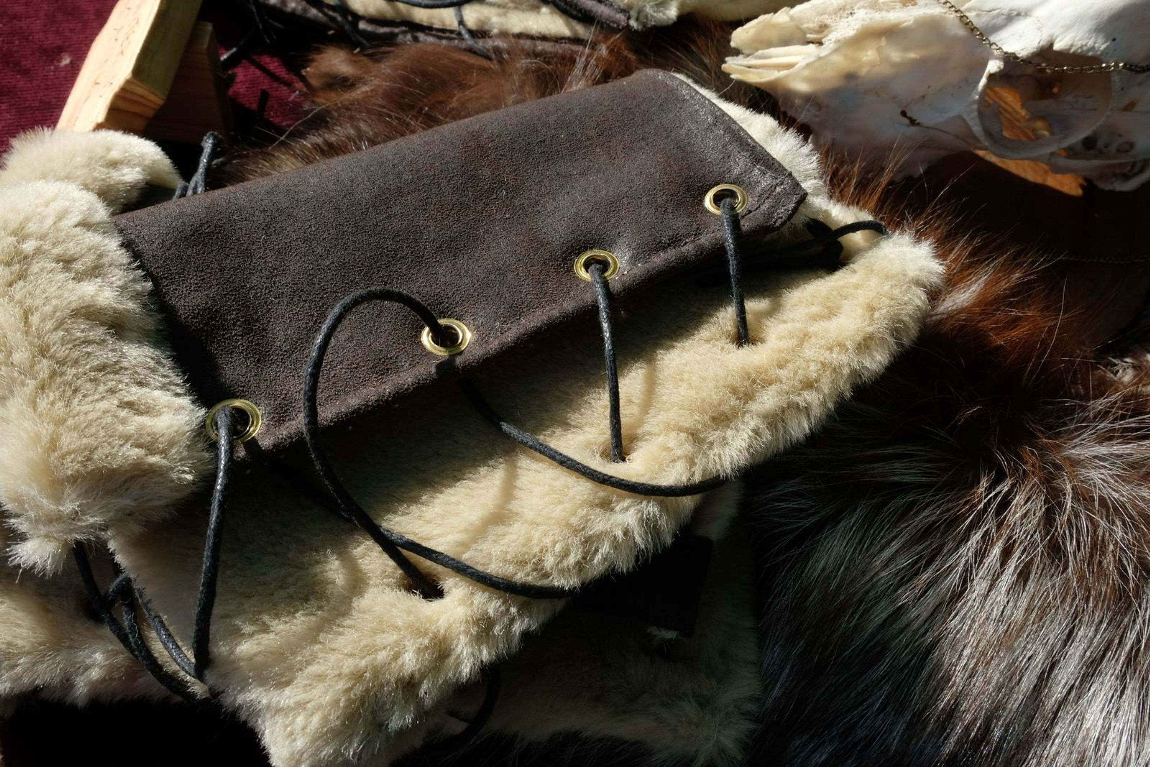 Fur-lined leather arm wraps with lacing, a Winter Is Coming sign and animal skull
