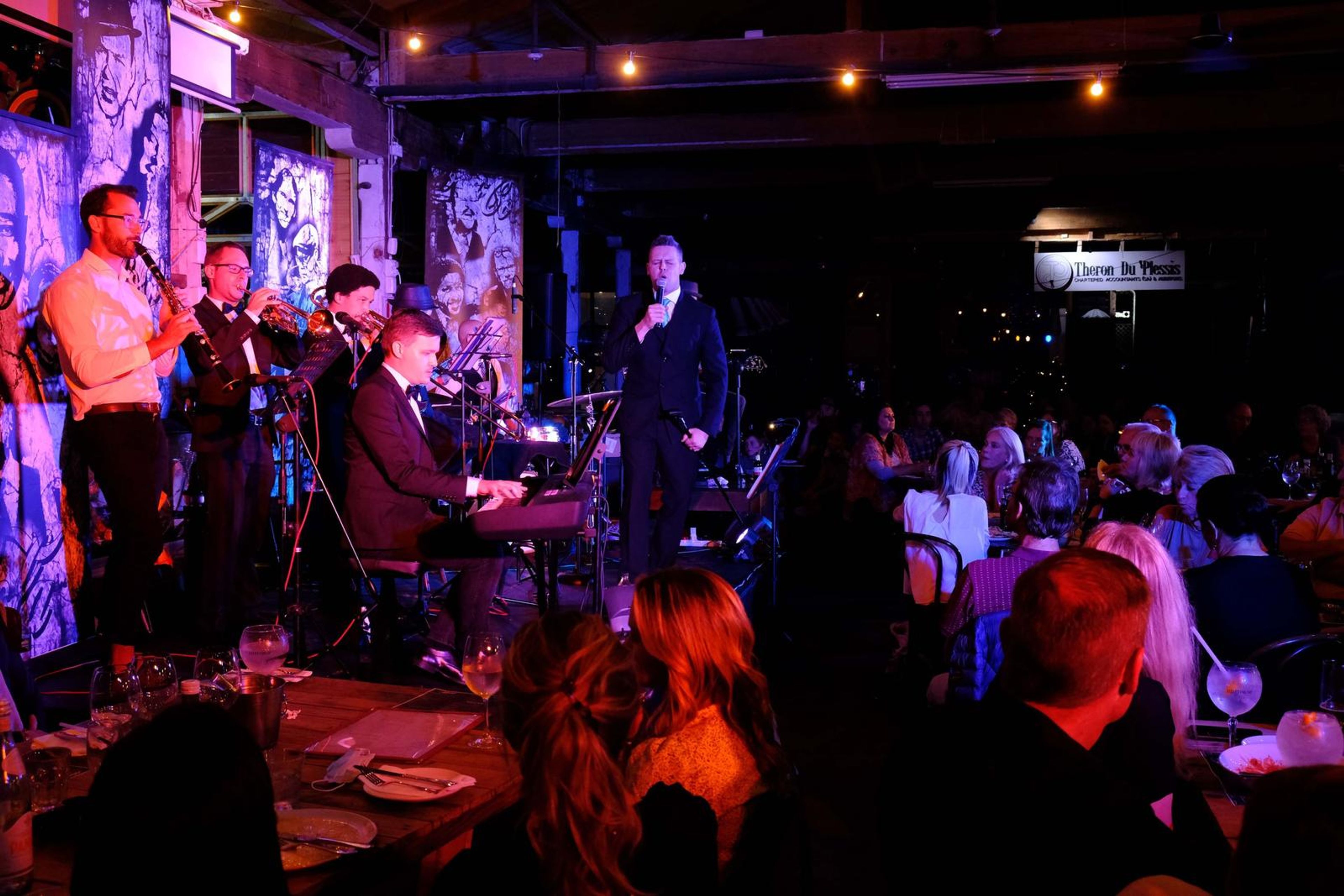 Wide view of the band on stage and the full restaurant