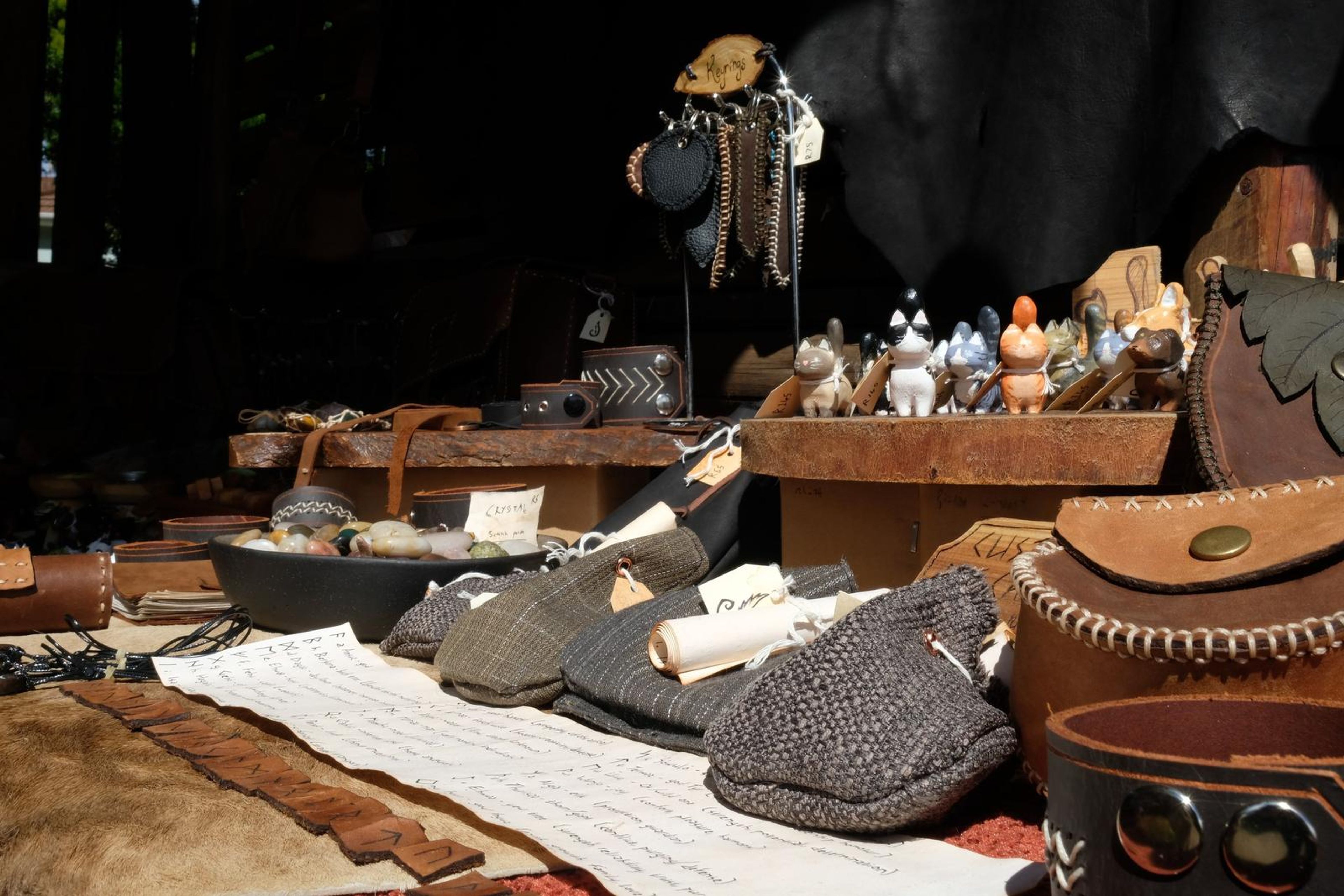Juuks table of leather pouches, carvings and cloth caps laid out on a white scroll