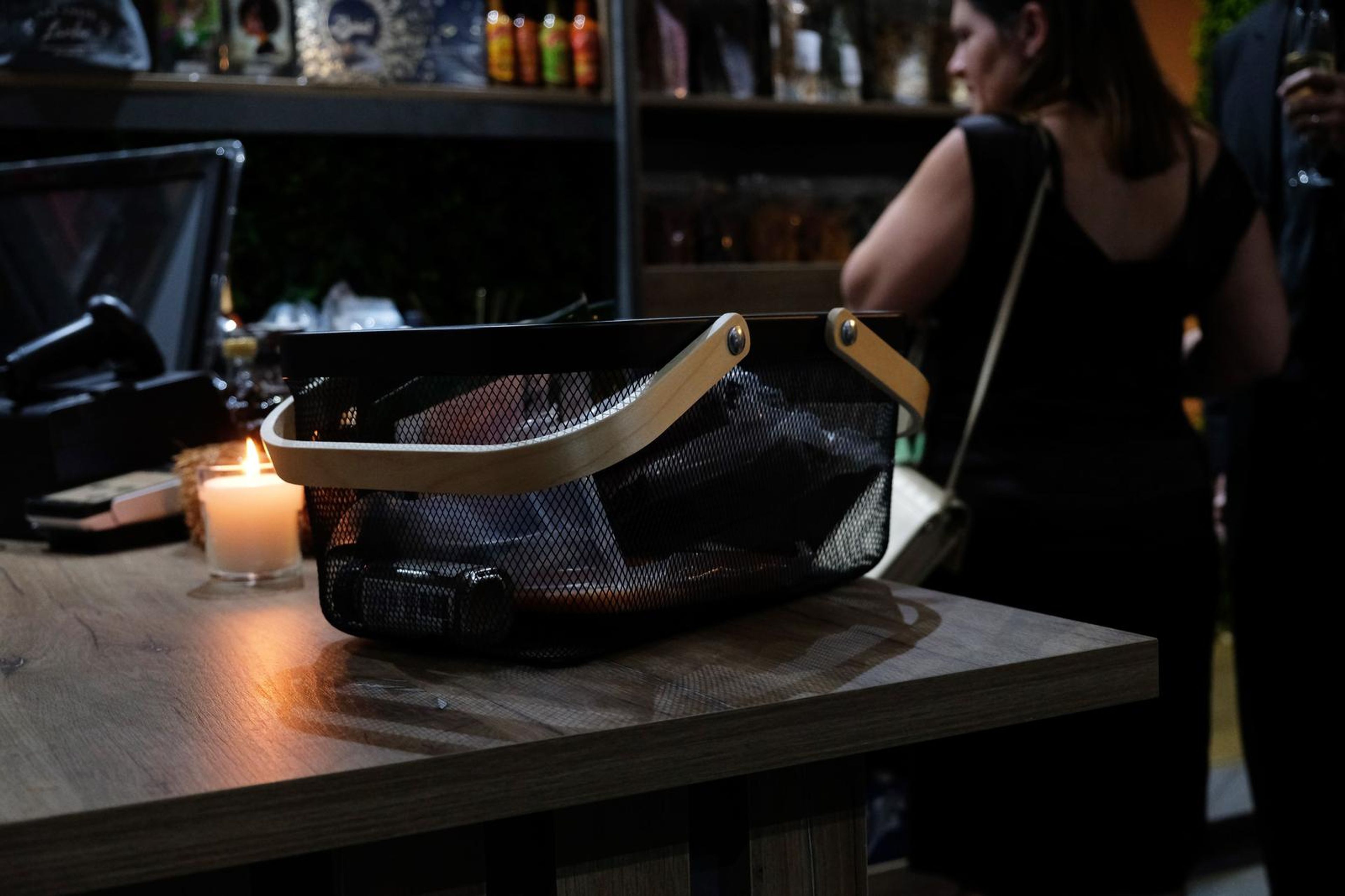 Shopping basket on the counter beside a lit candle