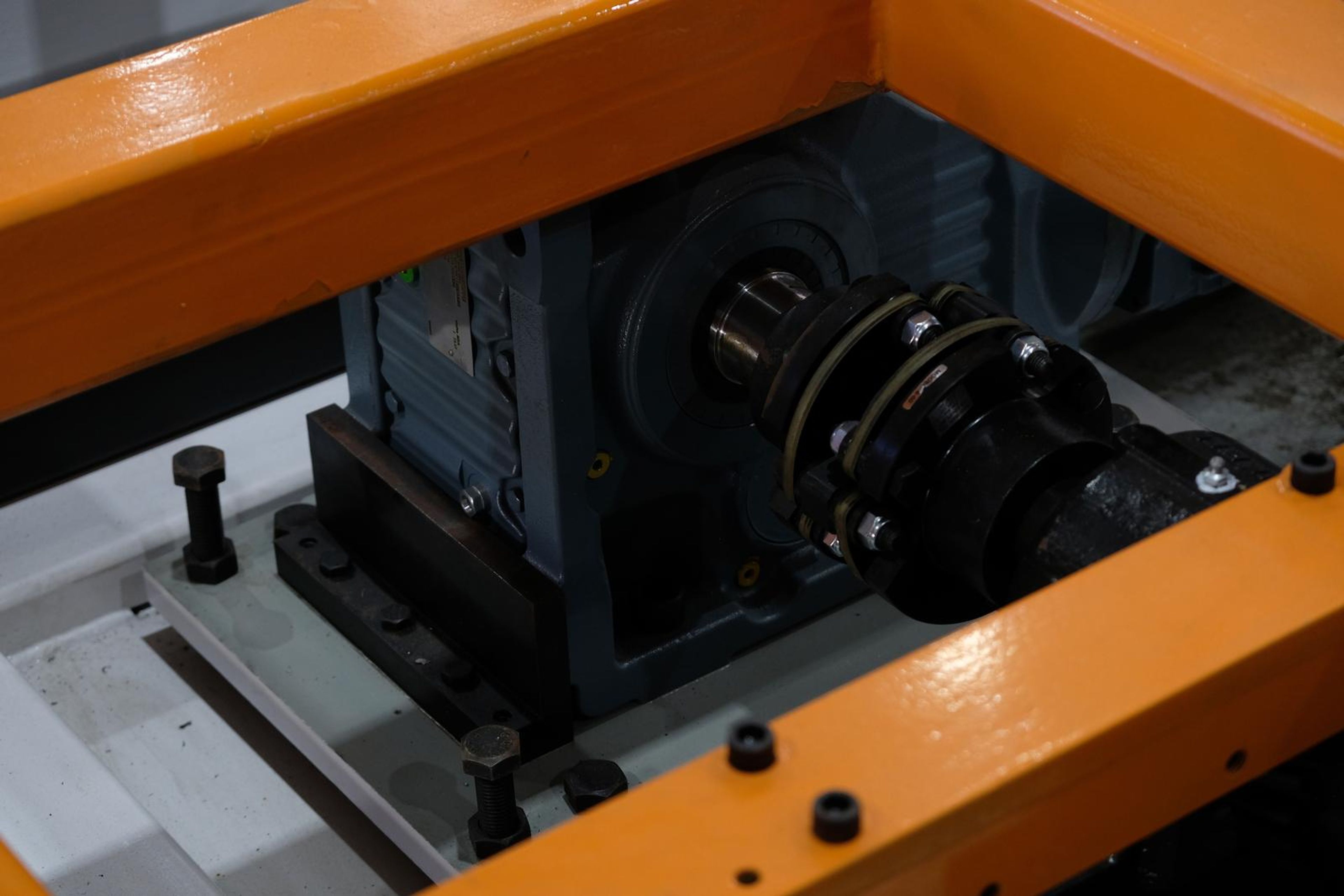 Gearbox coupling and bolts beneath an orange beam