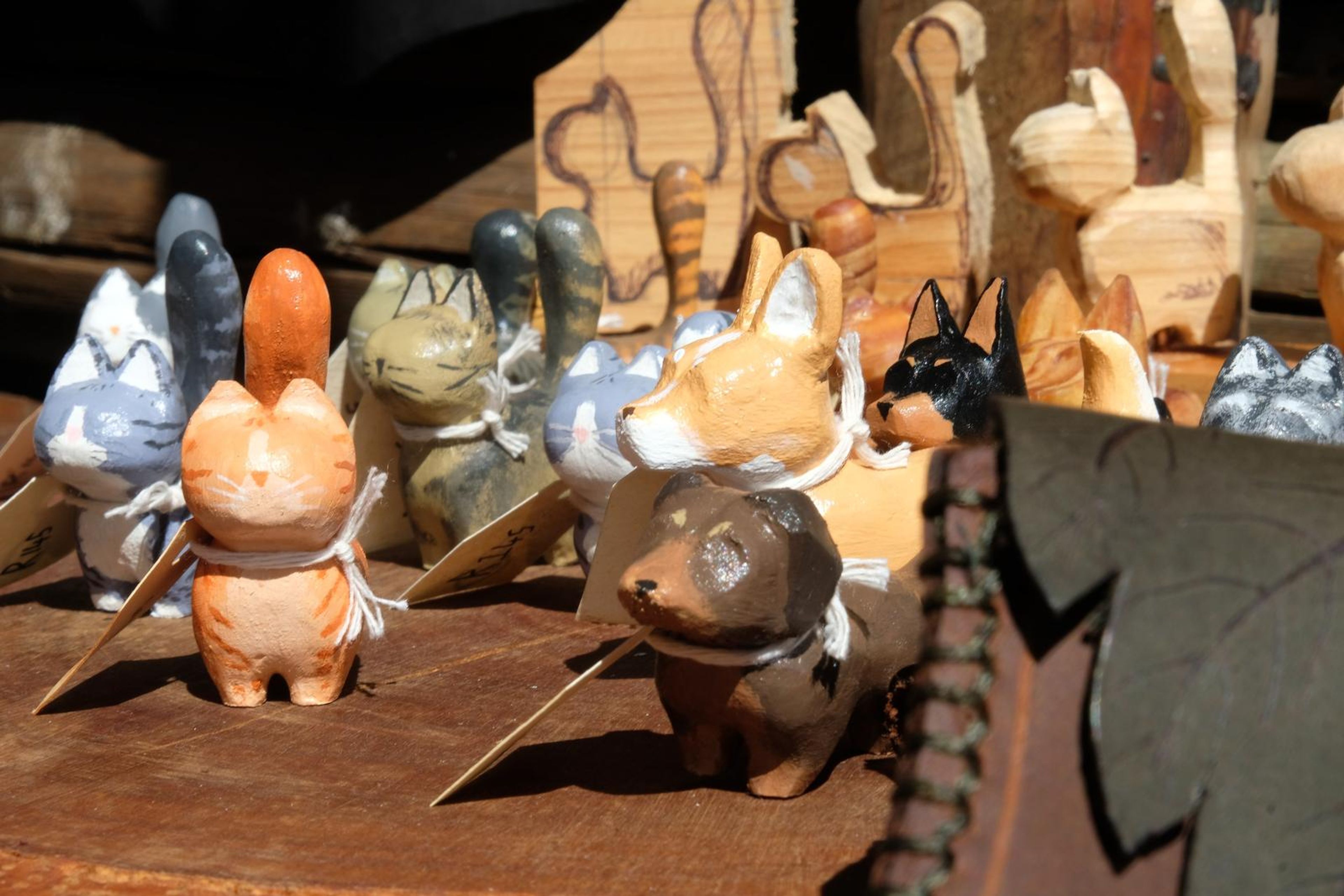 Hand-painted carved wooden cat figures with handwritten tags
