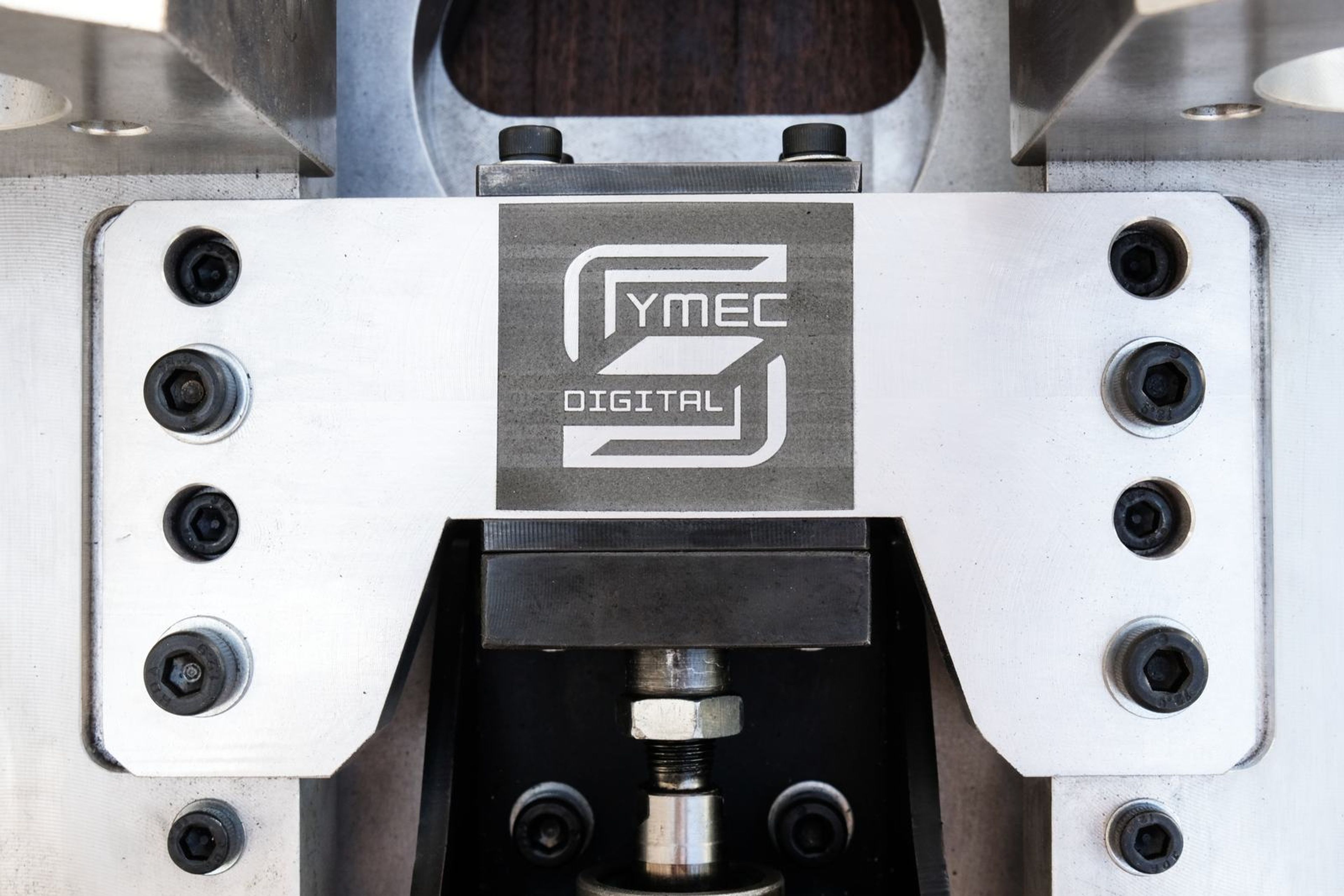 Close view of the engraved Symec logo plate between the clamping blocks
