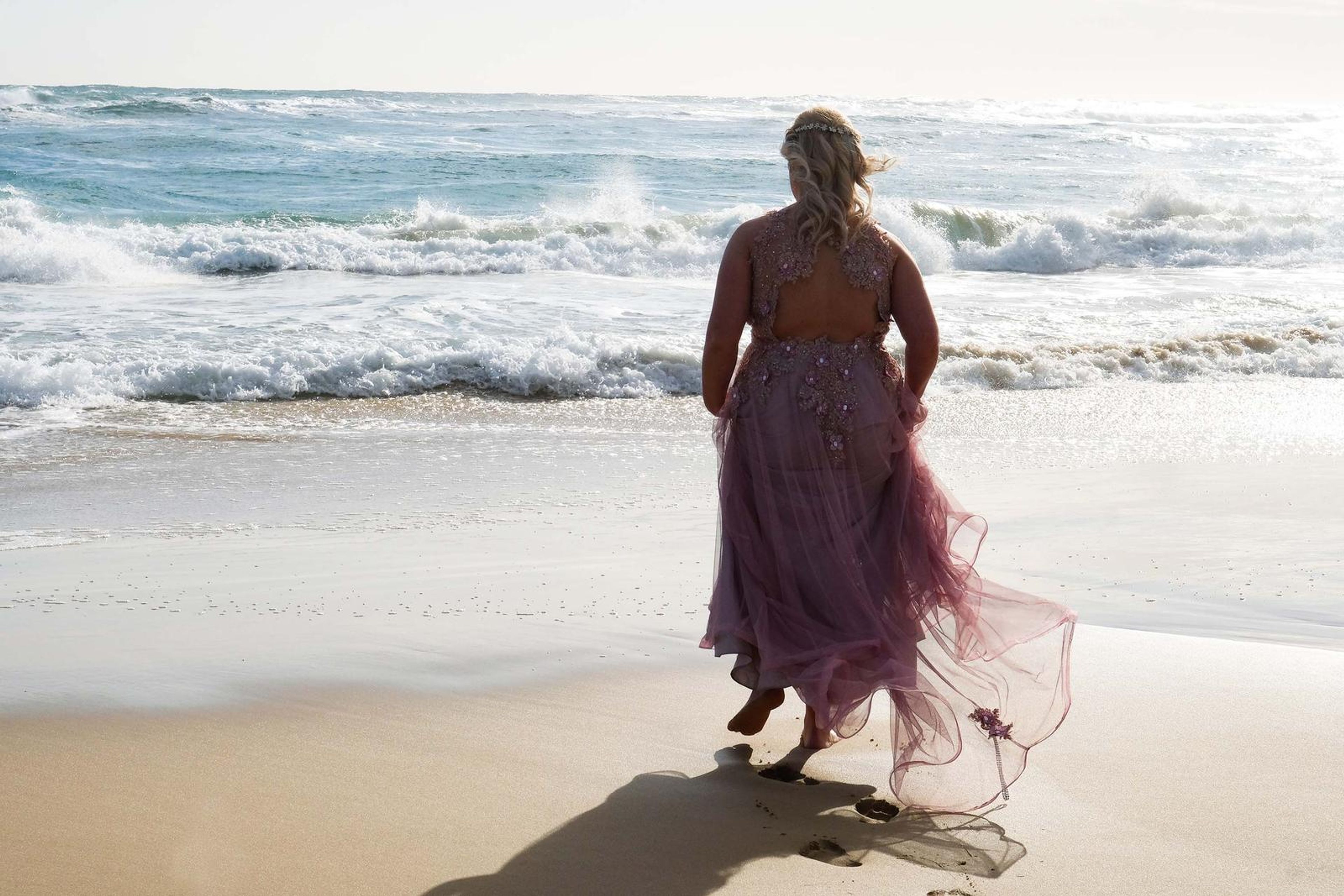 Walking away through the surf, back view