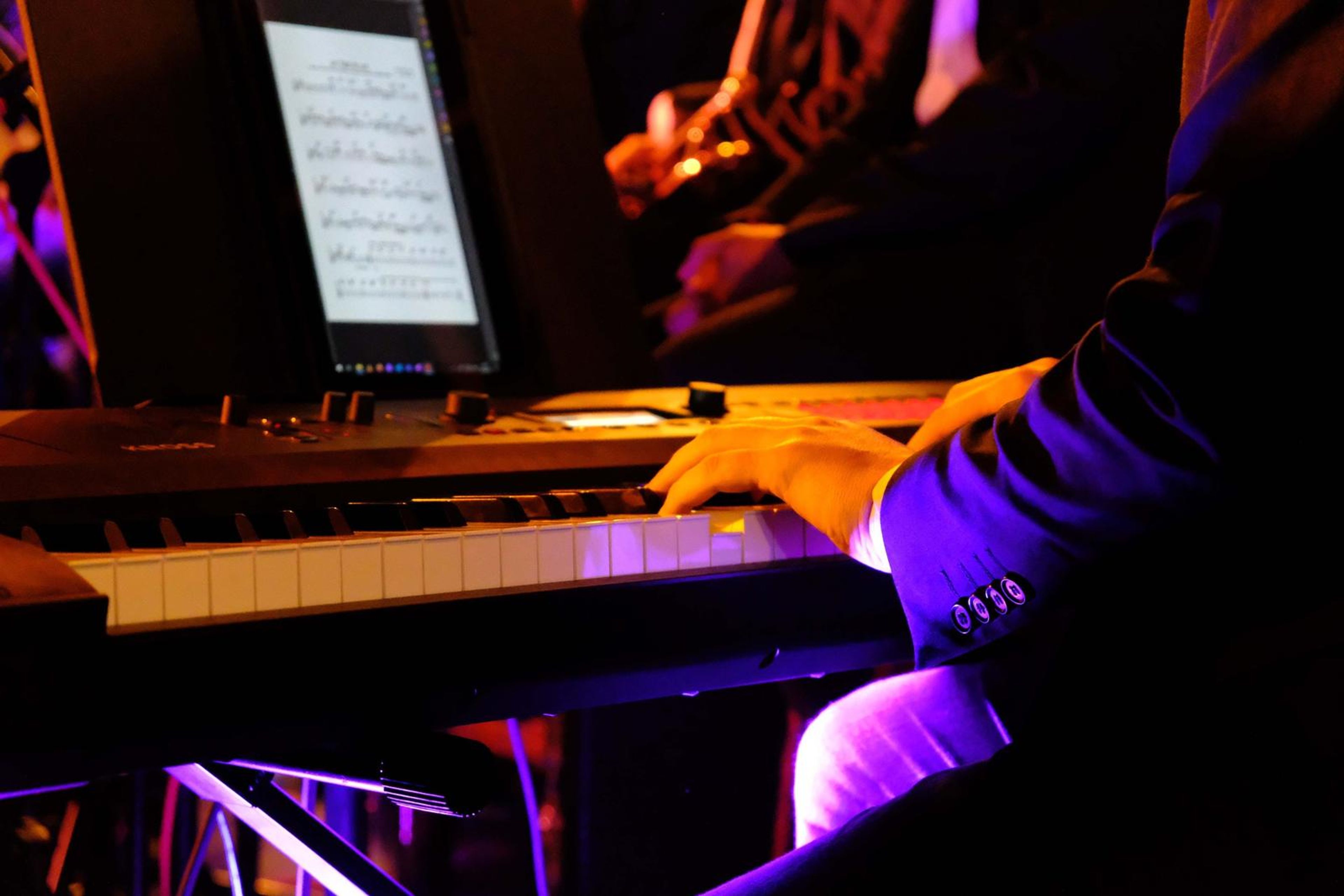 Keyboard player reading sheet music on a tablet