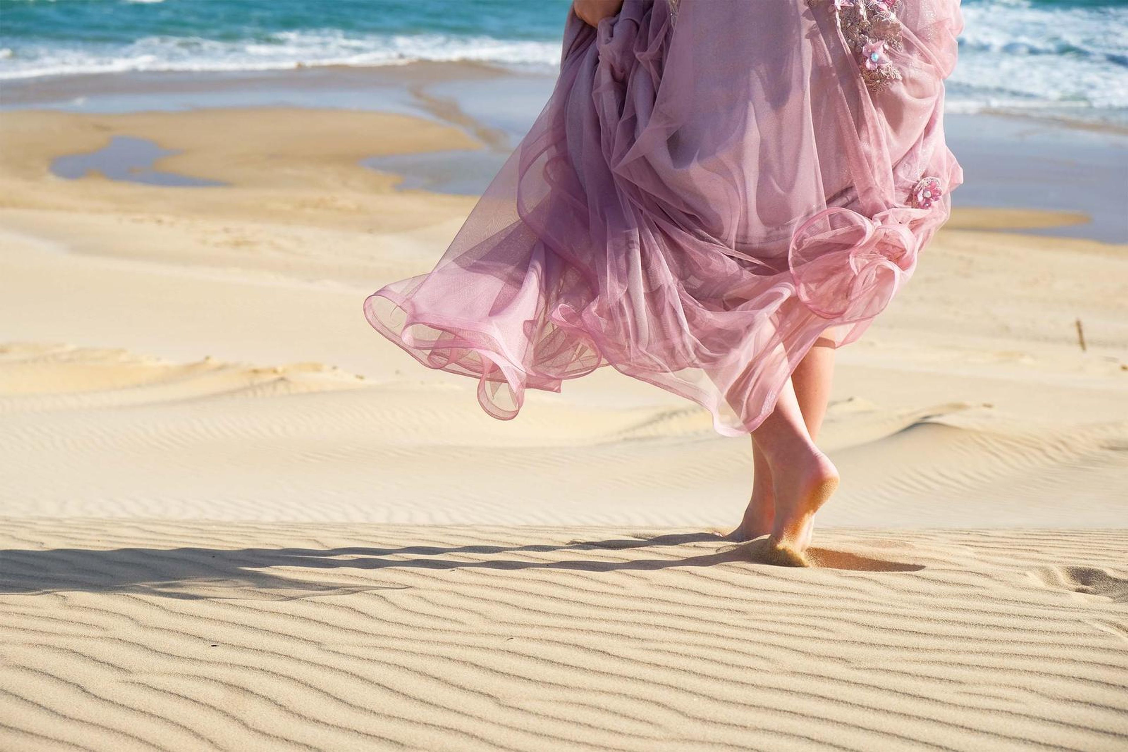 Close view of the gown skirt blowing across the sand