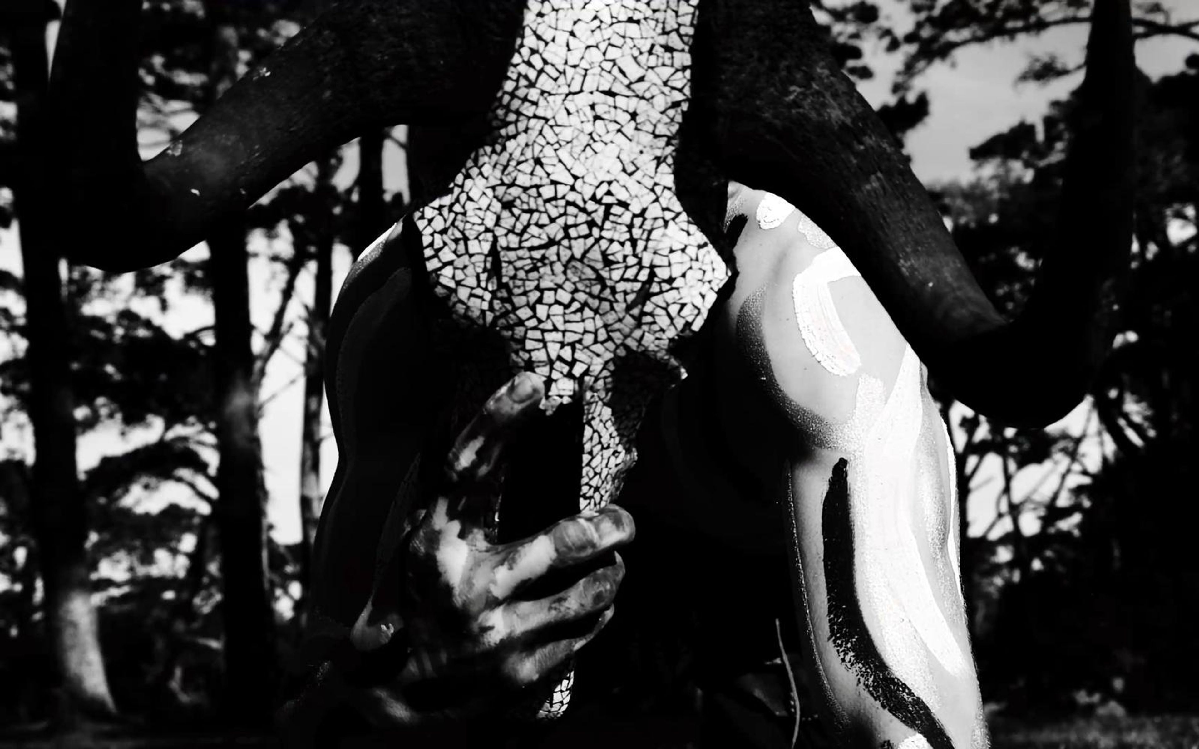 Skull face with a white-dotted pattern between curved horns in high contrast