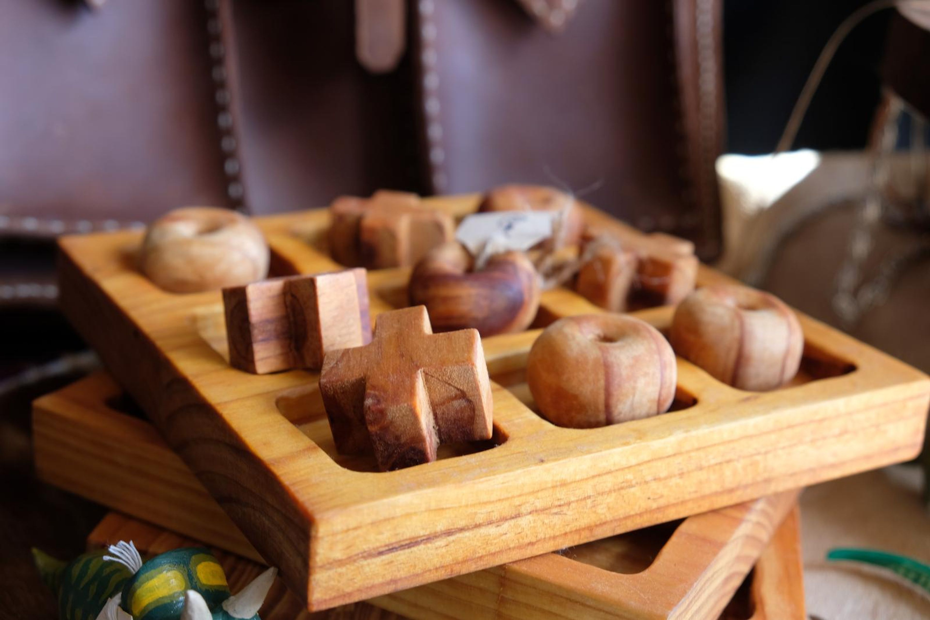 Hand-carved wooden tic-tac-toe board with carved pieces