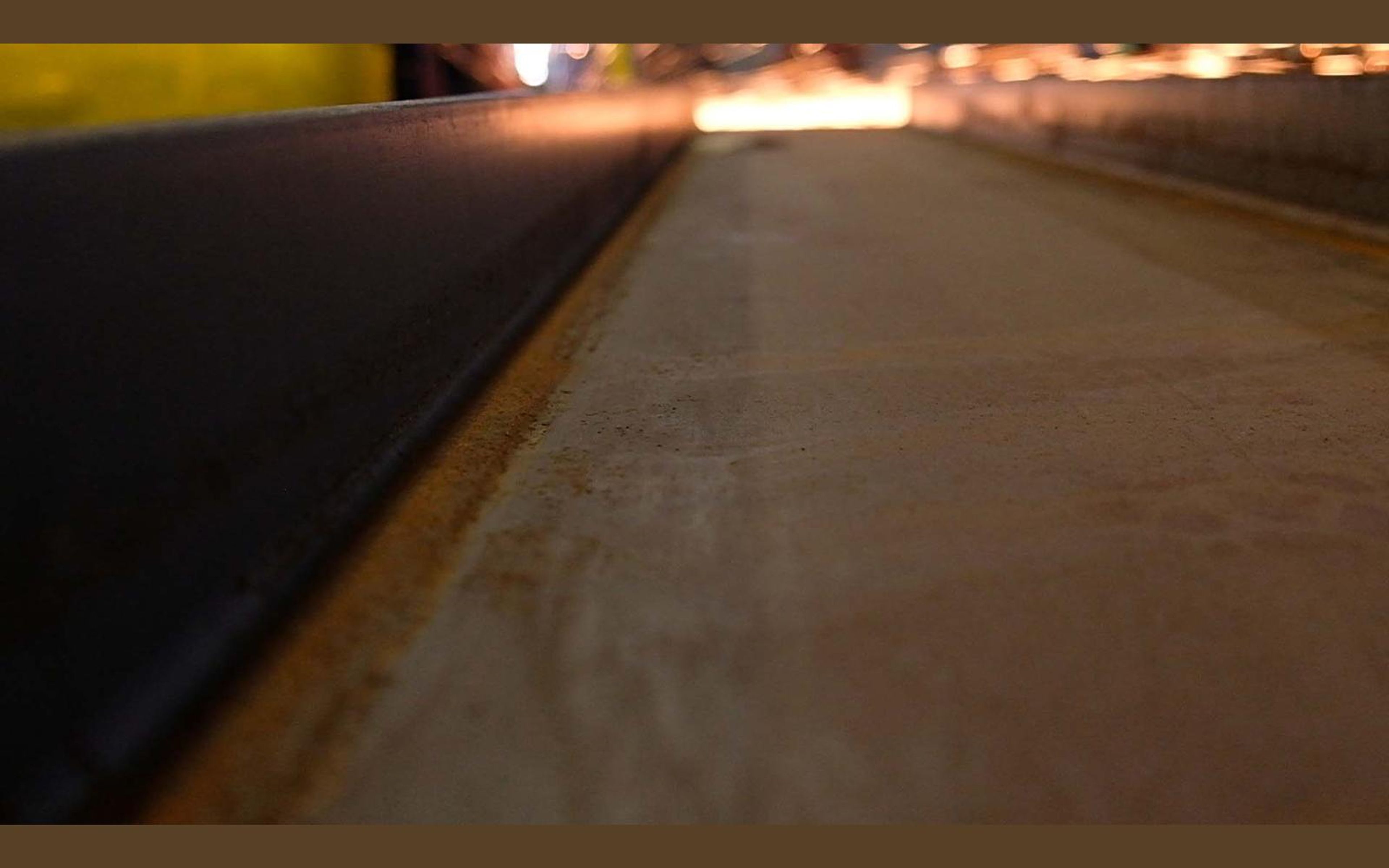 Long steel beam seen along its length on the shop floor