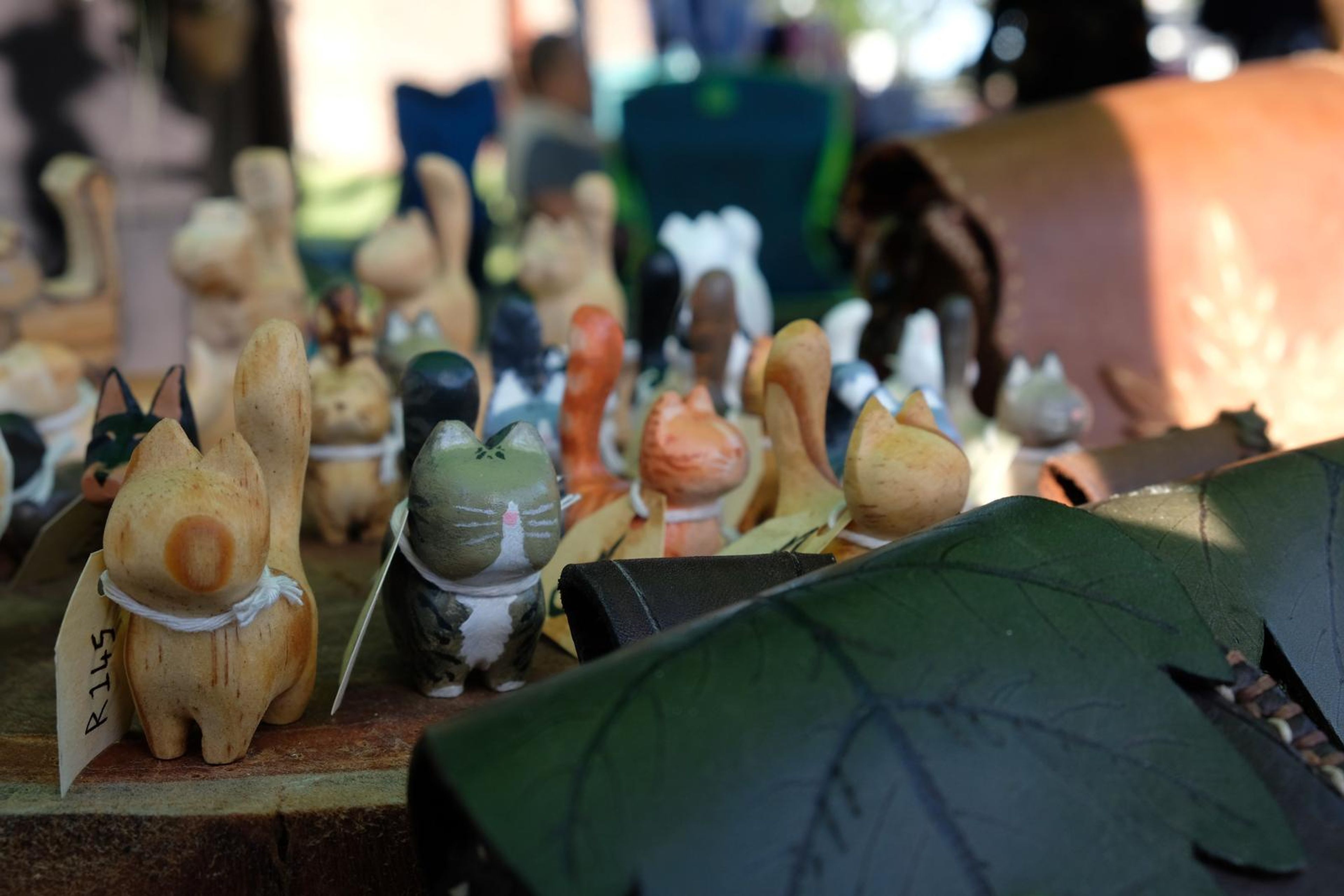 Close-up of hand-painted carved wooden pets on a bark slab