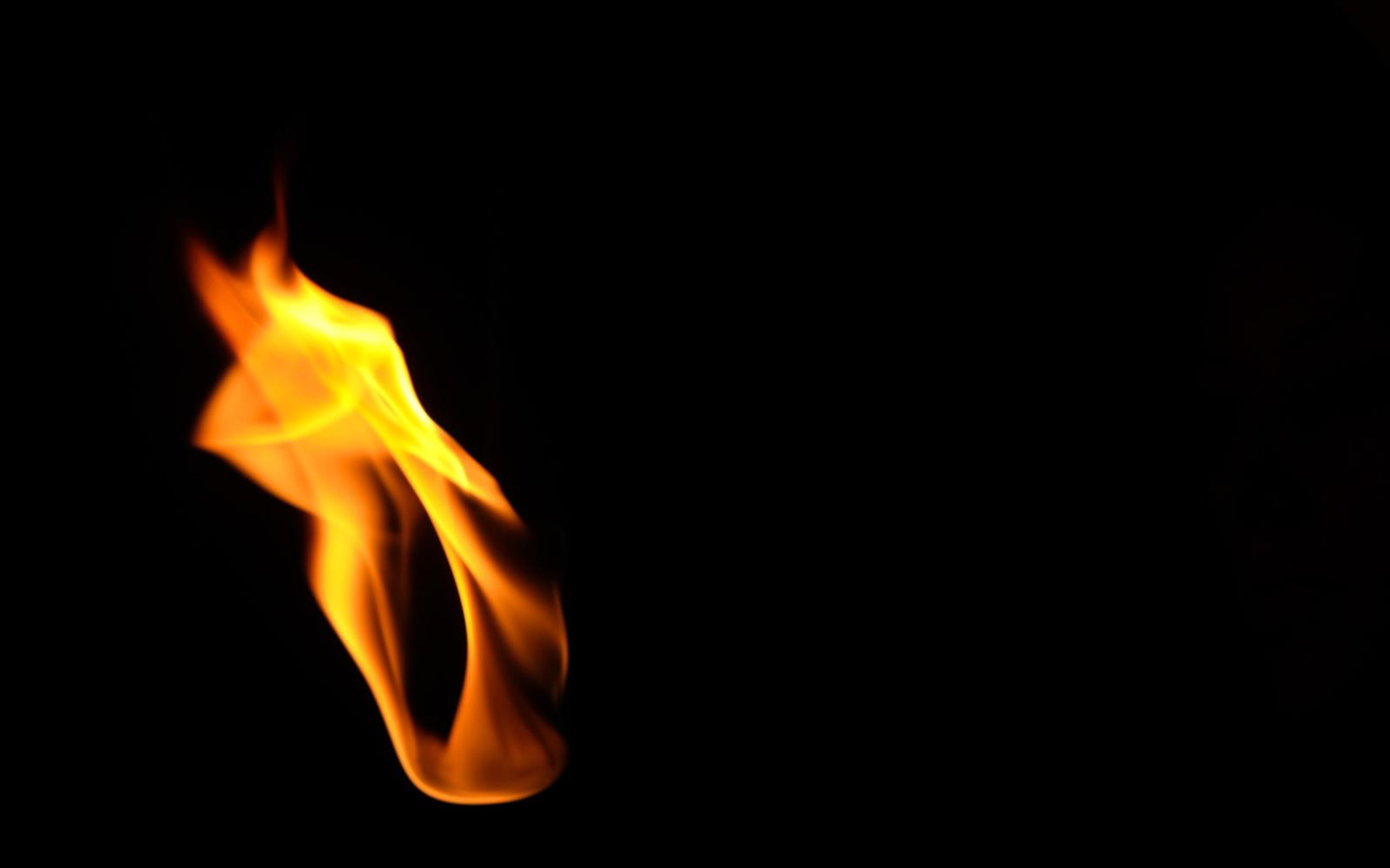 Compact flame leaning left with a soft rounded top