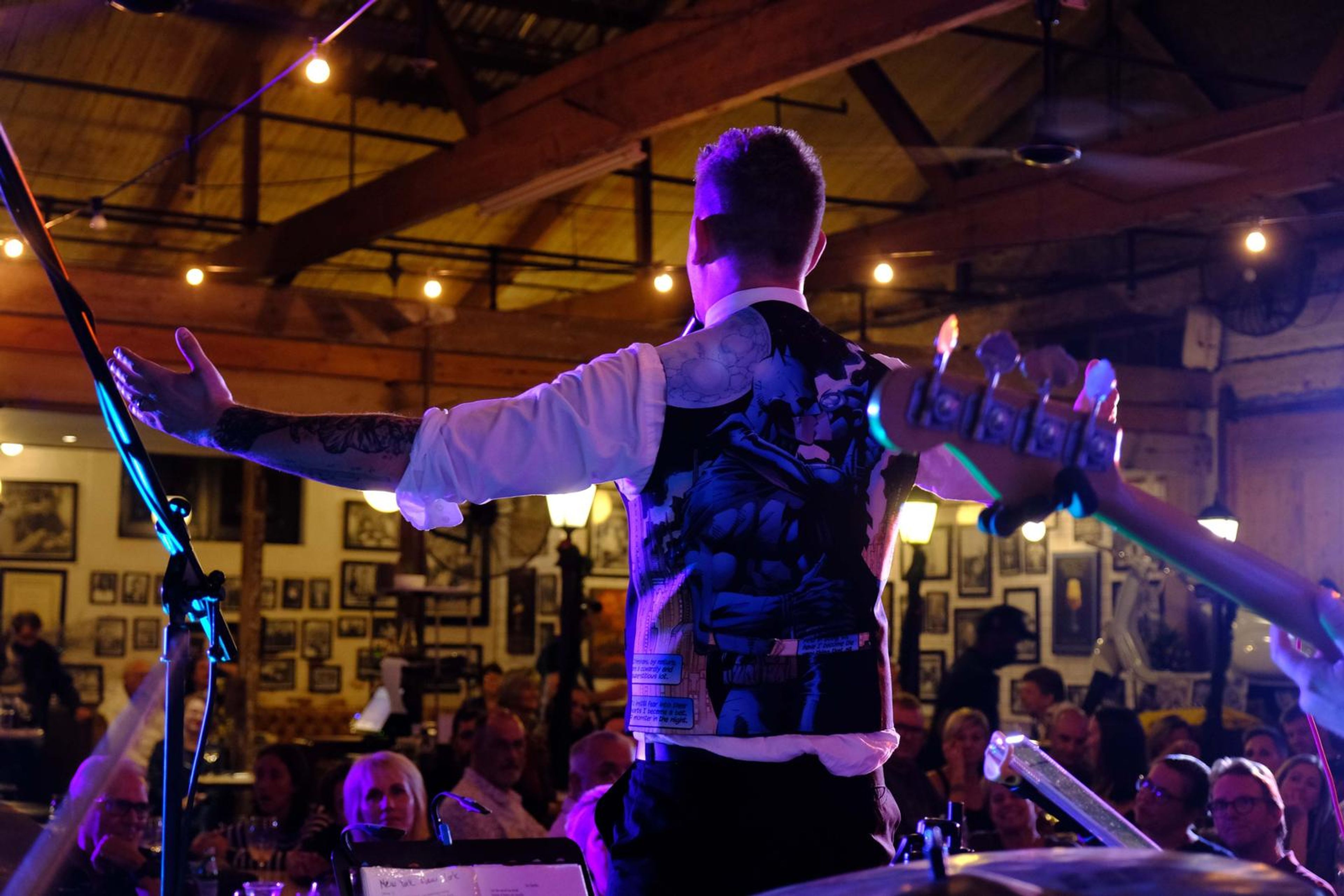 Singer with his arms outstretched in front of the packed restaurant