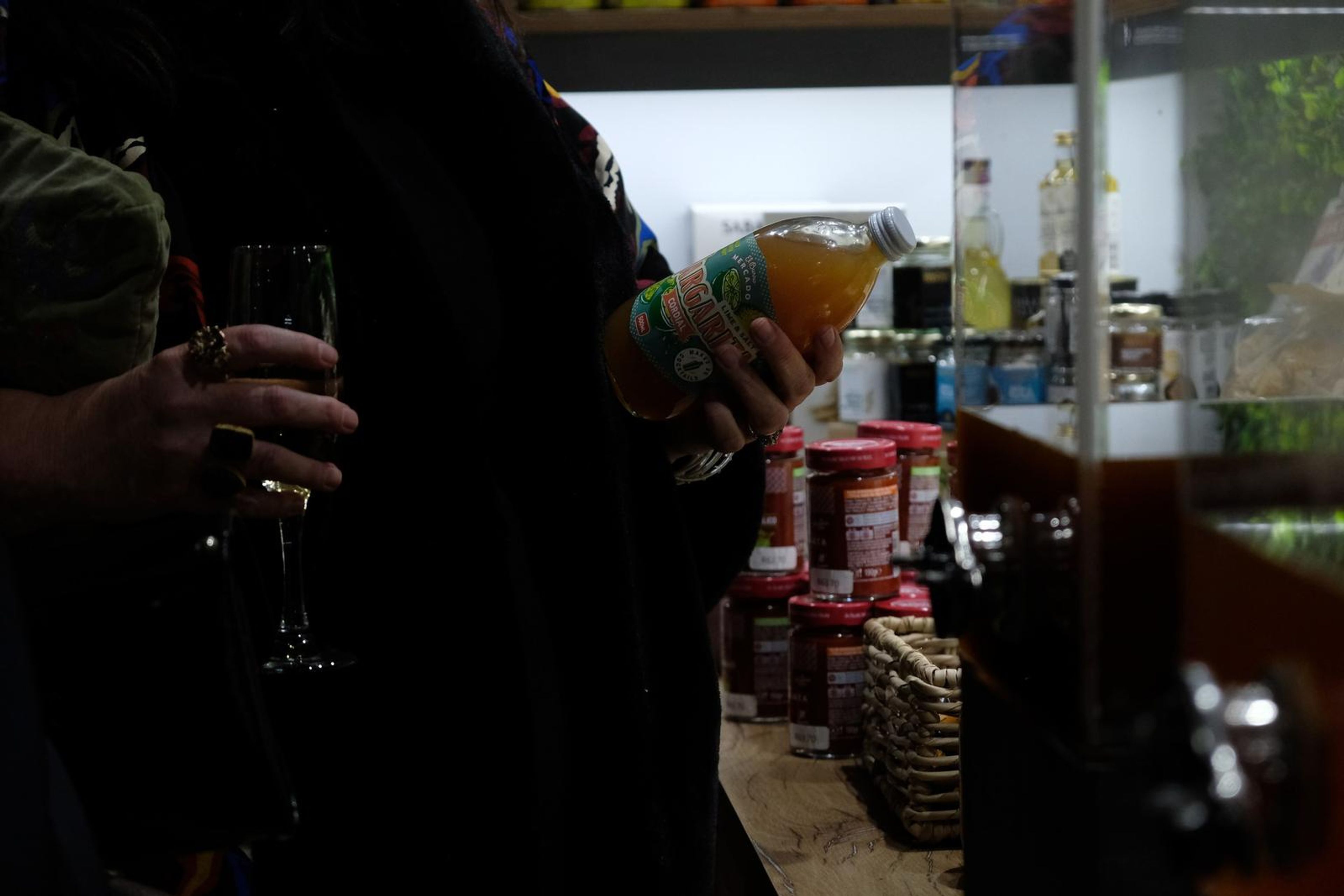 Guest holding a glass of champagne while pouring from a bottle of juice