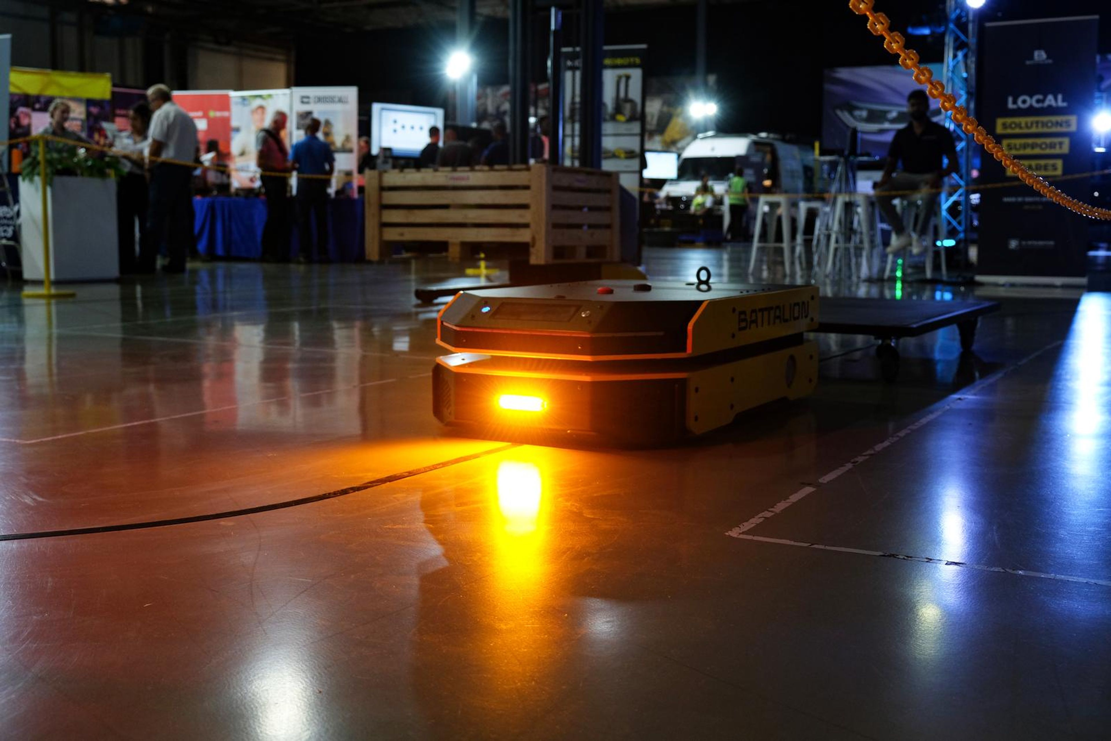 Autonomous mobile robot with an amber light moving across the expo floor