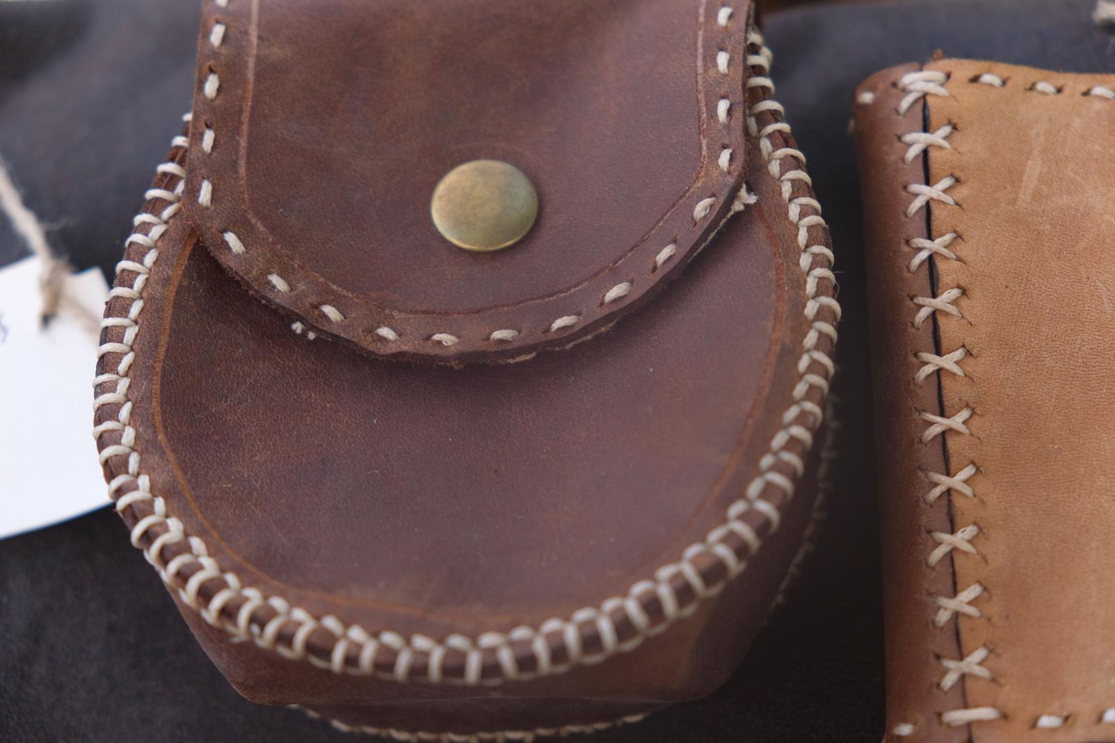 Round brown leather belt pouch with hand-stitched edging and a brass stud