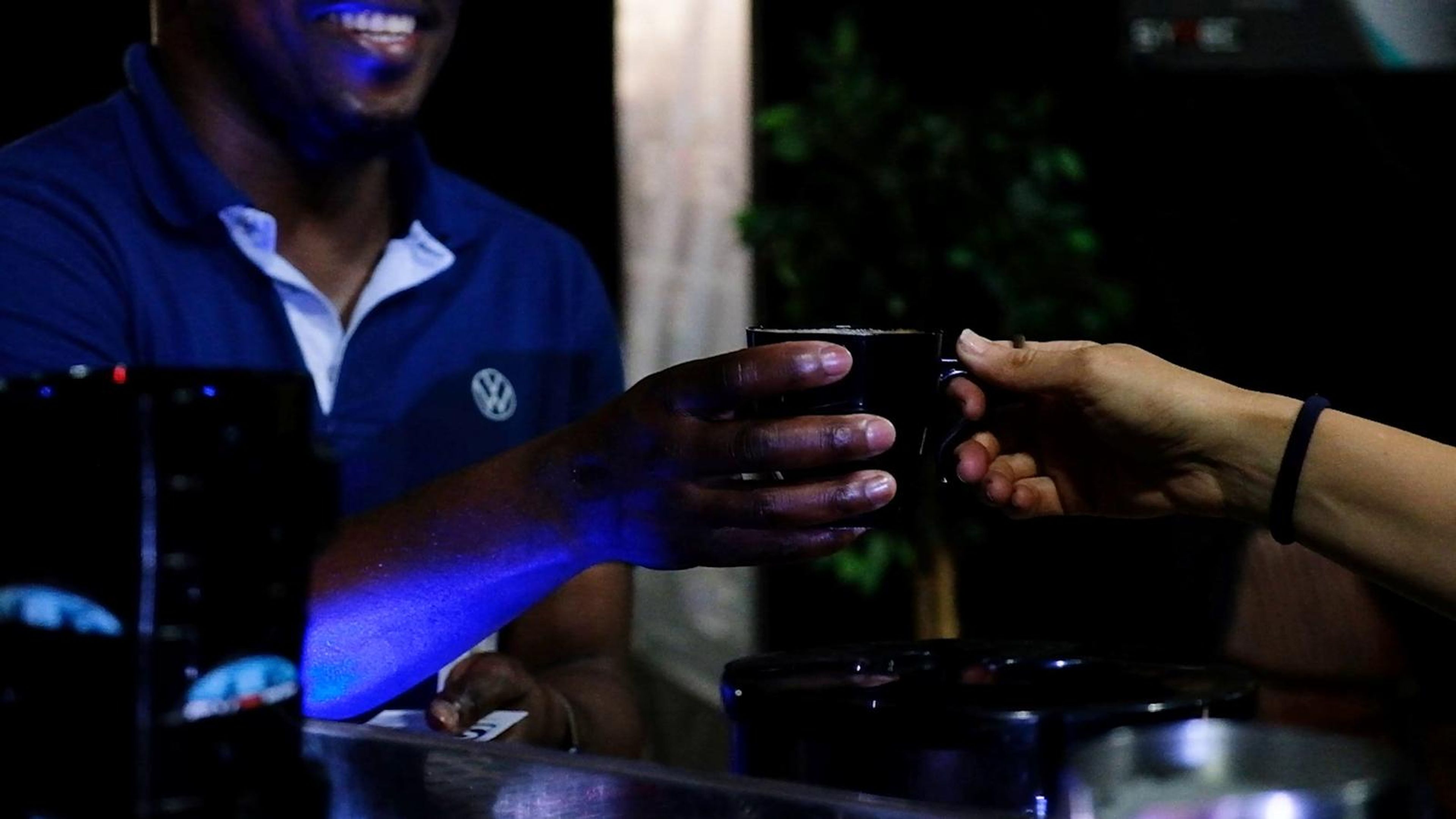 Volkswagen staff member smiling as a coffee is handed over