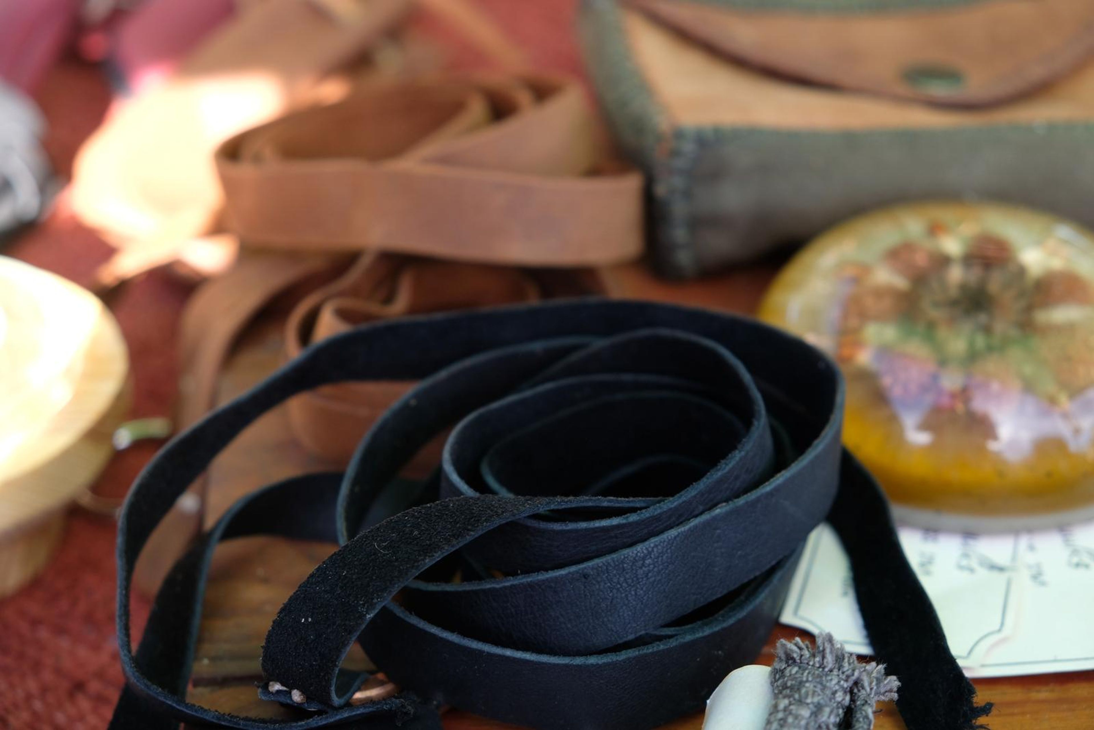 Coiled black leather strap beside a resin dome on the Juuks table